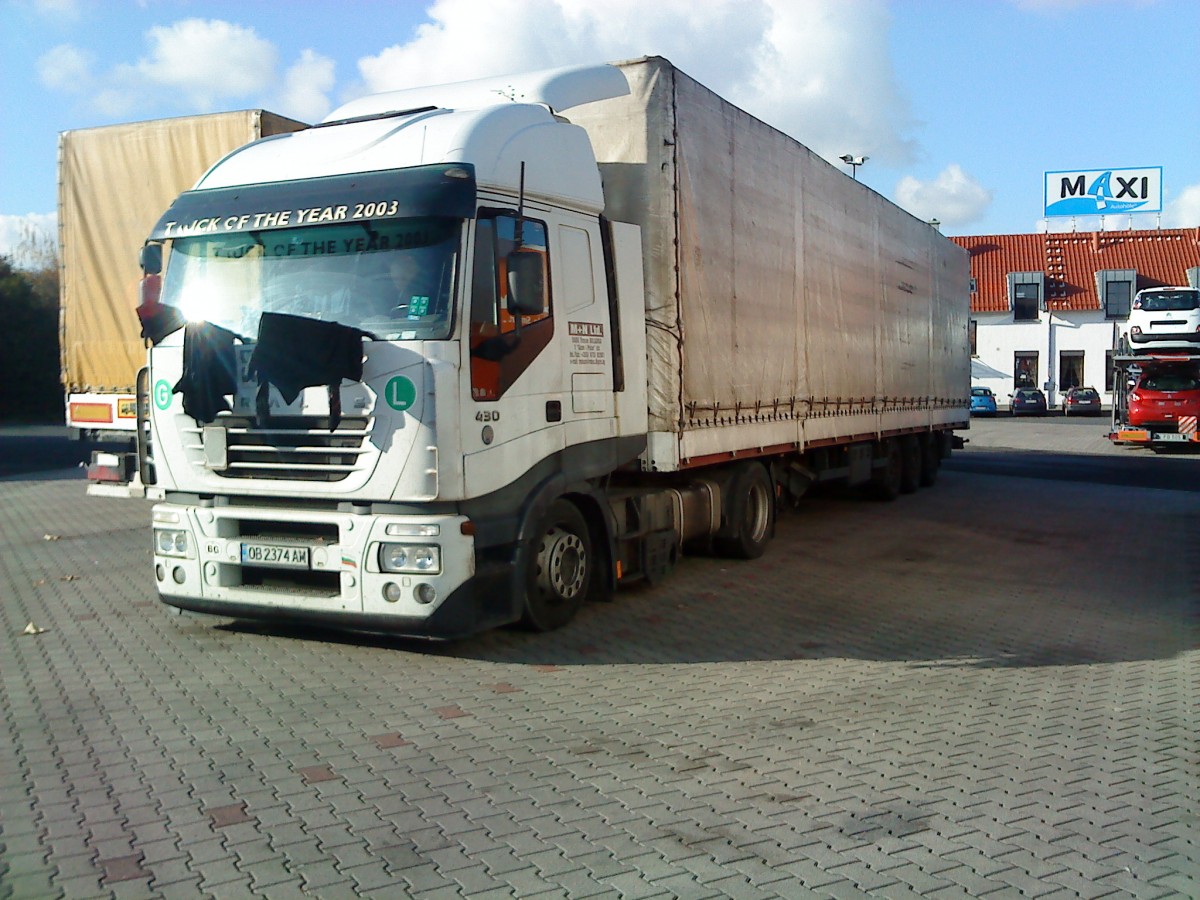 SZM IVECO Stralis mit Pritsche-Planen-Auflieger auf dem Autohof in Grnstadt am 11.11.2013