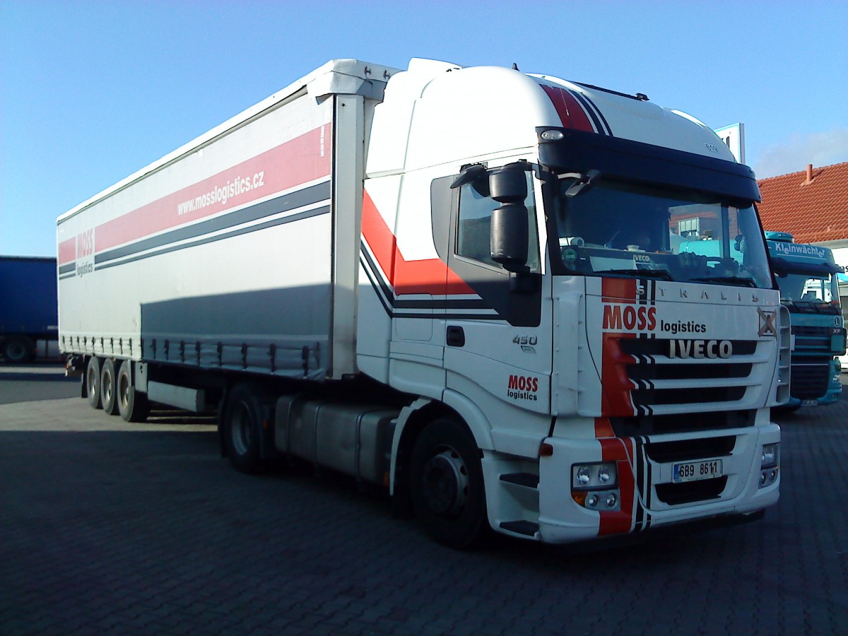 SZM IVECO Stralis mit Pritsche-Planen-Auflieger der Spedition Moss Logistics gesehen auf dem Autohof in Grnstadt am 26.02.2014