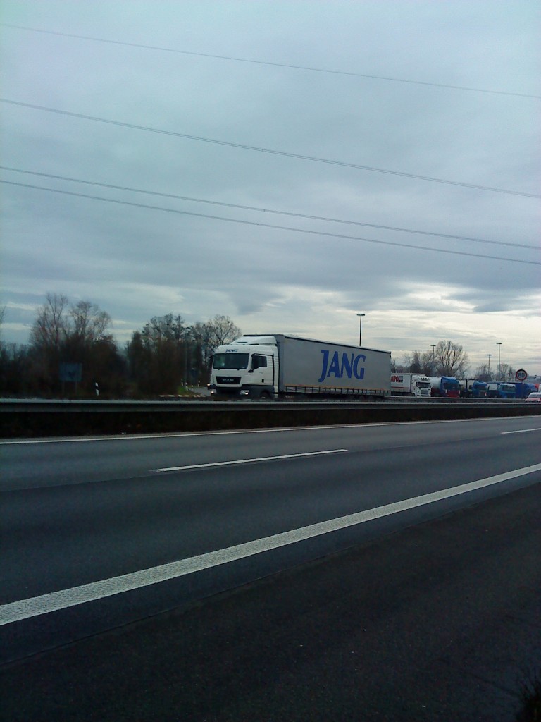 SZM MAN TGX 18.440 mit Pritsche-Planen-Auflieger der Spedition JANG gesehen auf der A61, Höhe Raststätte Dannstadt am 16.01.2014