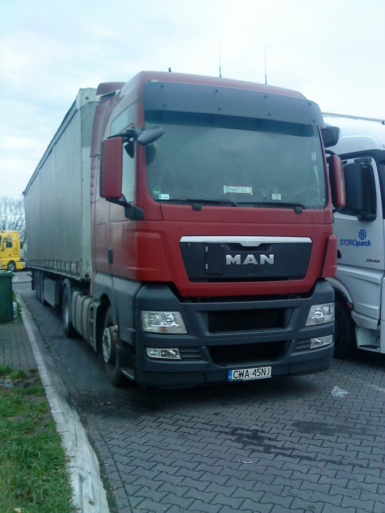 SZM MAN TGX 18.440 mit Pritsche-Planen-Auflieger aus Polen gesehen auf dem Parkplatz der Raststtte Dannstadt an der A 61 am 16.01.2014