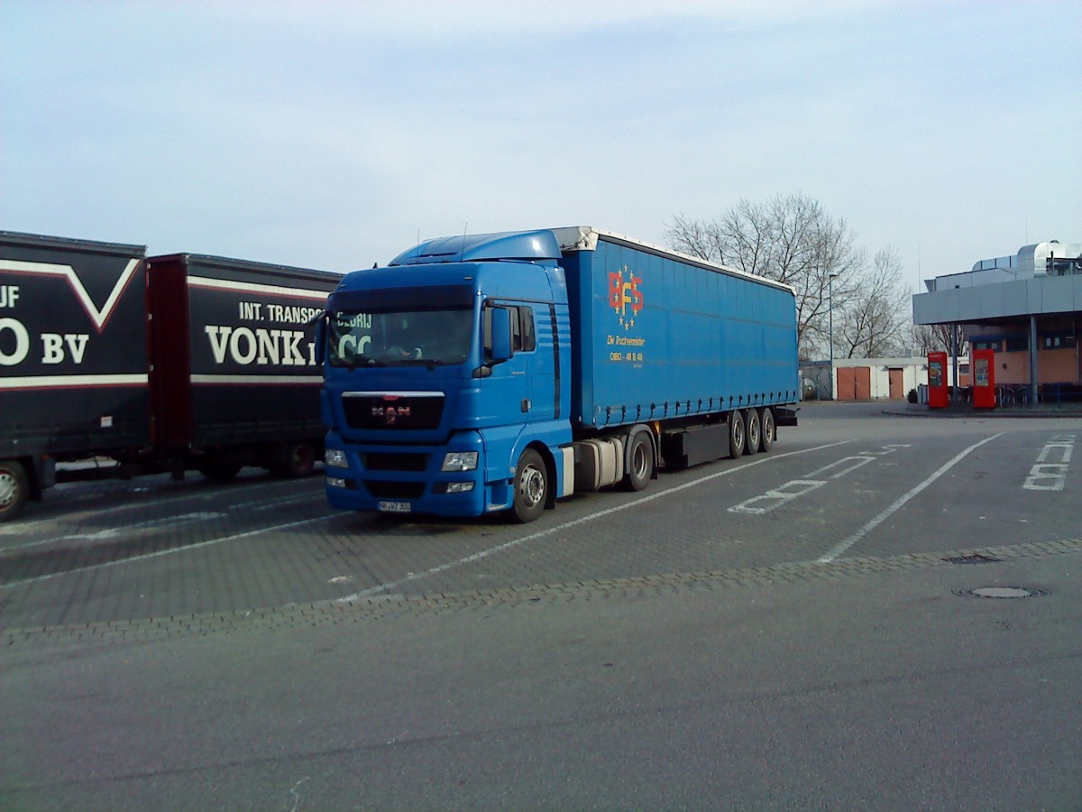 SZM MAN TGX 18.440 mit Pritsche-Planen-Auflieger gesehen auf dem Rasthof Dannstadt an der A 61 am 18.02.2014