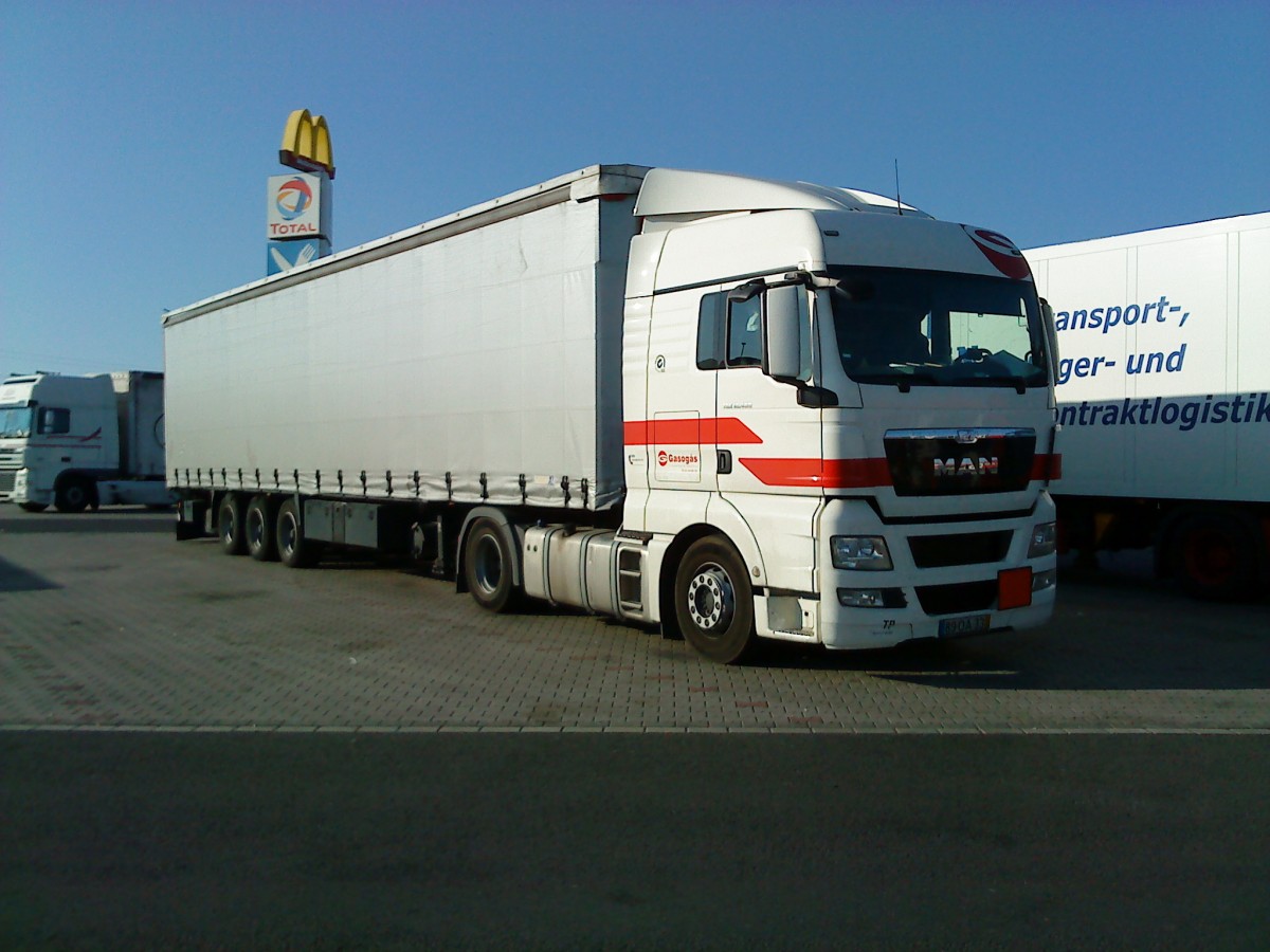 SZM MAN TGX 18.440 mit Pritsche-Planen-Auflieger gesehen auf dem Autohof in Grnstadt am 14.07.2014