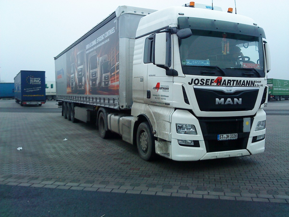 SZM MAN TGX mit Pritsche-Planen-Auflieger der Spedition Josef Hartmann GmbH & Co. KG Greven auf dem Autohof in Grnstadt am 12.12.2013