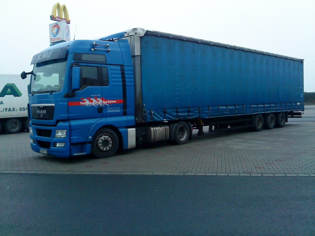 SZM MAN TGX mit Pritsche-Planen-Auflieger der Spedition R. Wolf Bad Waldsee auf dem Autohof in Grnstadt am 11.12.2013