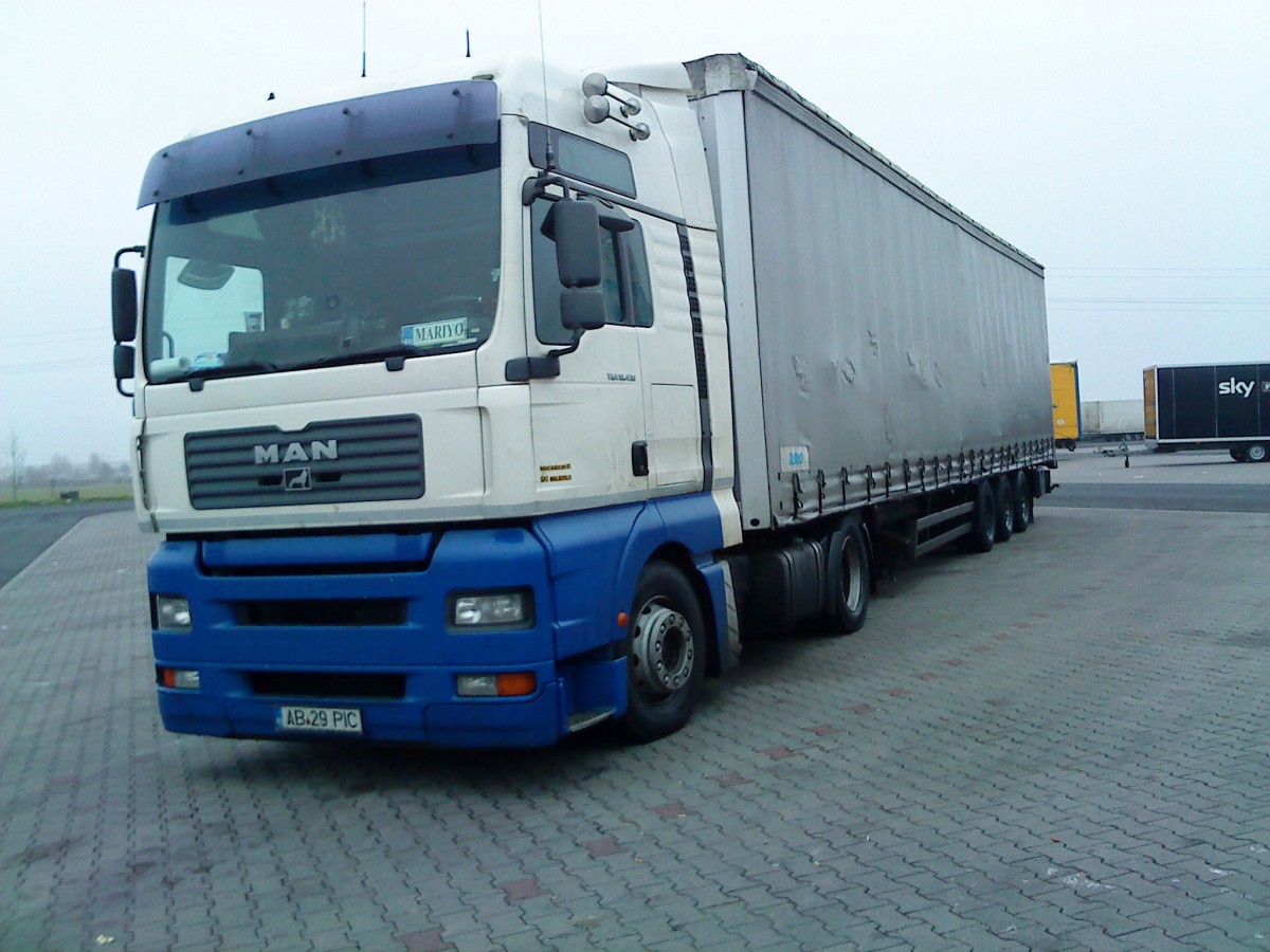 SZM MAN TGX mit Pritsche-Planen-Auflieger auf dem Autohof in Grnstadt am 12.12.2013