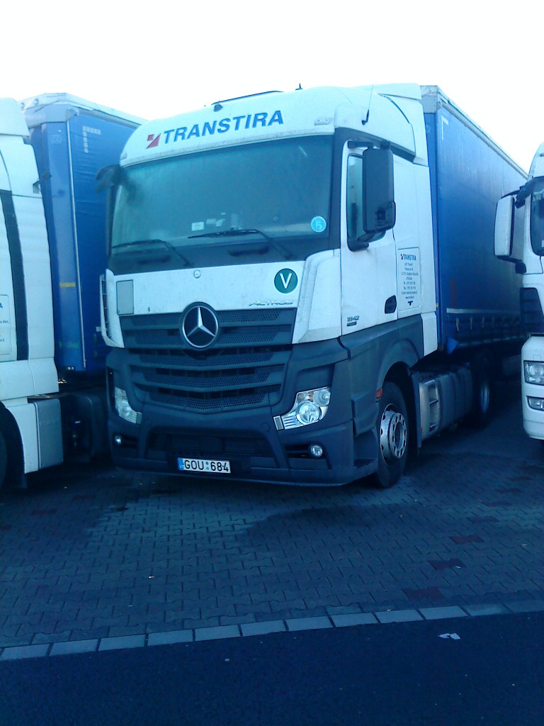 SZM Mercedes-Benz Actros 1842 mit Pritsche-Planen-Auflieger der Spedition Transtira auf dem Autohof in Grnstadt am 30.12.2013