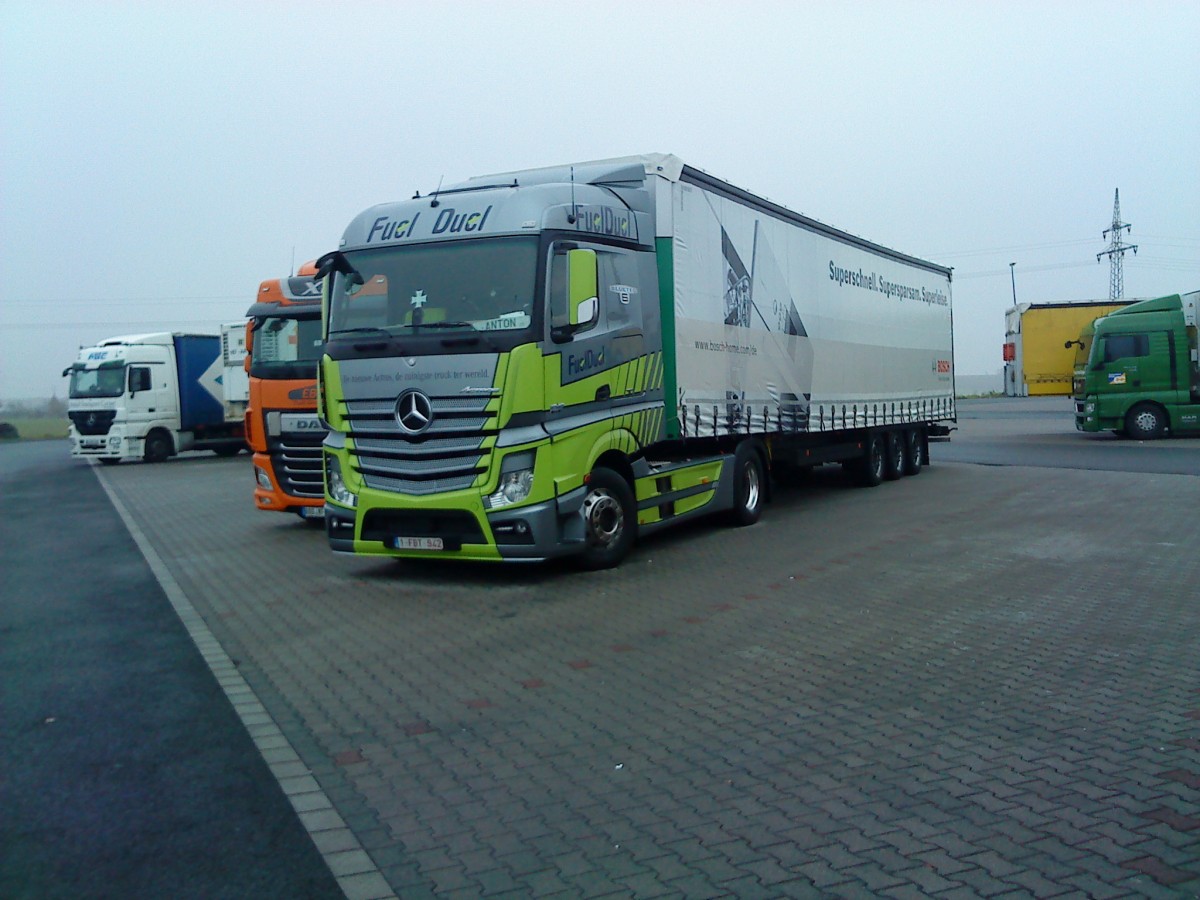 SZM Mercedes-Benz Actros 1845 mit Pritsche-Planen-Auflieger auf dem Autohof in Grünstadt am 11.12.2013