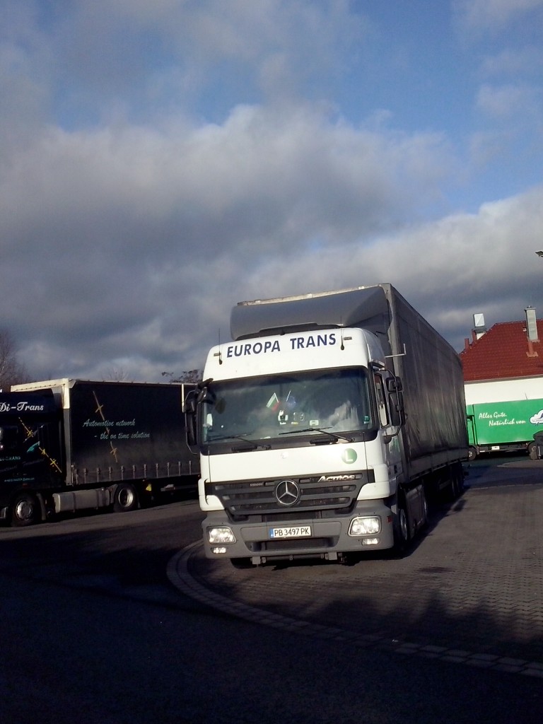 SZM Mercedes-Benz Actros mit Pritsche-Planen-Auflieger der Spedition Europa Trans gesehen auf dem Autohof in Grnstadt am 13.02.2014