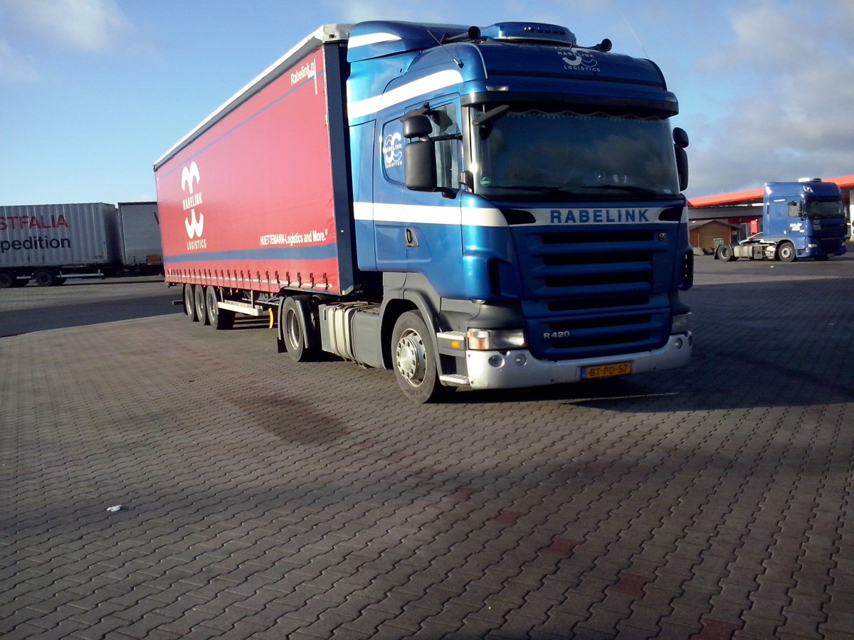 SZM SCANIA R 420 mit Pritsche-Planen-Auflieger der Spedition Rabelink auf dem Autohof in Grnstadt am 13.02.2014