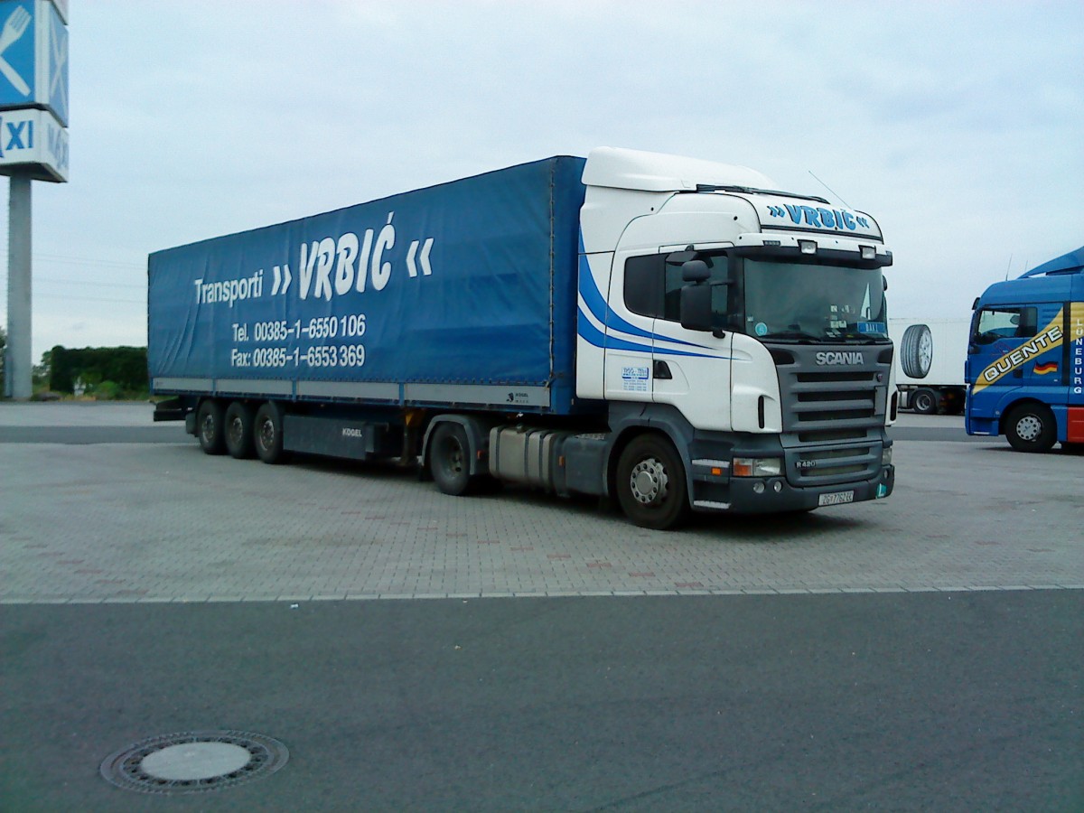 SZM SCANIA R 420 mit Pritsche-Planen-Auflieger der Spedition Vrbic auf dem Autohof in Grünstadt am 18.06.2014