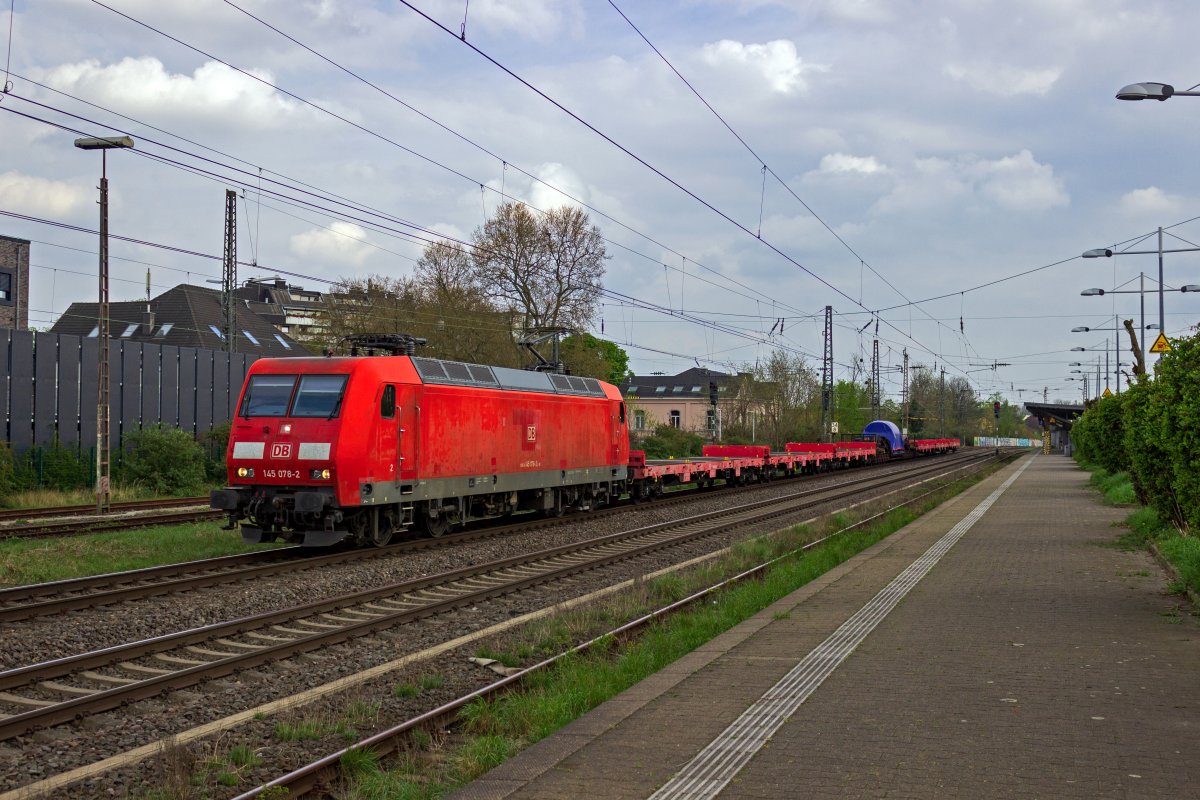 Tiefladewagen f�r Schwerlasttransporte geh�ren zu den selten anzutreffenden Fahrzeugen auf deutschen Schienen. 145 078 schleppt einen Wagen der Bauart Uaais 819 mit einem nicht zu identifizierenden, aber sicherlich schweren Ladegut durch Hilden. Um die Bremskraft des Zuges zu verbessern sind neben dem zw�lfachsigen Tiefladewagen sechs weitere leere Flachwagen in den Zug eingereiht.