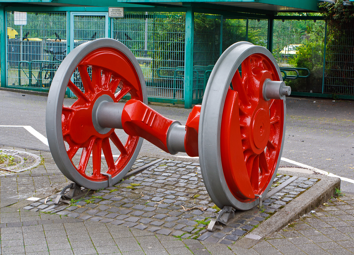 Treibachse (Kropfachse) einer schweren Gterzug-Dampflokomotive der Baureihe 044 am 04.06.2014 vor dem Empfangsgebude vom Bahnhof Betzdorf/Sieg.

Die Treibachse erinnert an die im ehemaligen AW Betzdorf beheimateten Dampflok, unteranderem an die ab 1966 bis 1975 im BW Betzdorf (vom BW Siegen bernommenen) stationierten schweren Dreizylinder-Dampflokomotiven der Baureihe 44  ( Jumbo´s ).

Hauptschlich waren jedoch (in den 1940er bis 1976) im BW Betzdorf Gterzuglokomotiven der Baureihe 50 stationiert, da ihre Achslast nur 15t betrug und so auf allen Strecken fahren konnte, in den 1950er-Jahren gehrten aber auch Loks der BR 57 (Preuische G 10) zum Bestand.