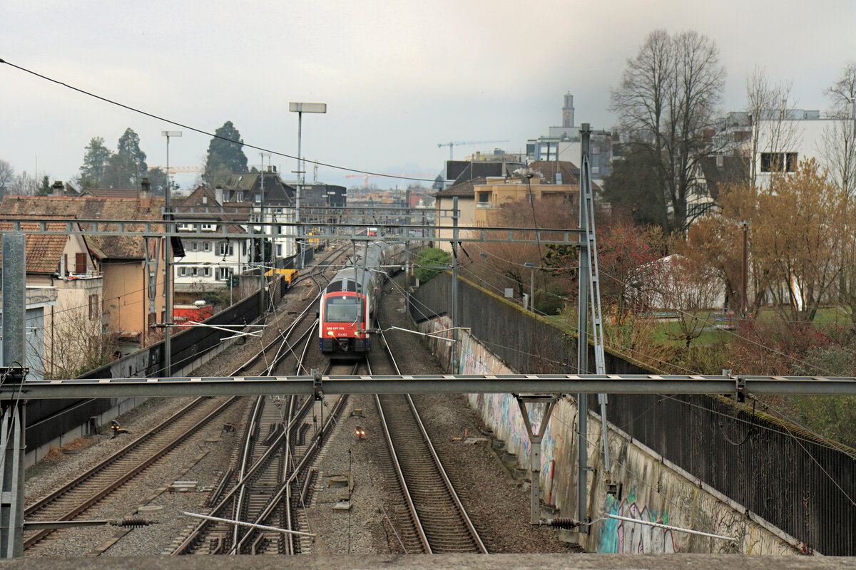 Triebzug 514 023 wird als S2 ohne Halt der Seestrecke entlang fahren nach Zürich. Rechts unten wäre der Eingang zur Tunnelstrecke direkt nach (Wiedikon und) Zürich. Thalwil, 6.Februar 2023. Die Linie S2 fährt ab Ziegelbrücke (an Wochenenden Unterterzen am Walensee) mit nur wenigen Halten dem Zürichsee entlang bis Zürich (Löwenstrasse) und weiter über Oerlikon zum Flughafen. 
 