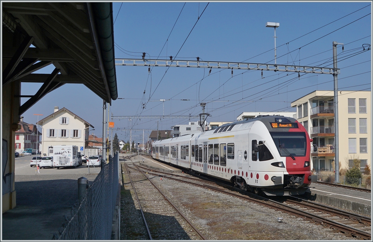 Trotz des Zauns an der Güterverladerampe beim Güterschopf widerspiegelt die Station Sugiez Ambiente, wie sie vor gut dreissig, vierzig Jahren noch auf fast allen Landstationen zu finden war. Im Bild: Der TPF RABe 527 195 verlässt Sugiez in Richtung Romont.

9. März 2022