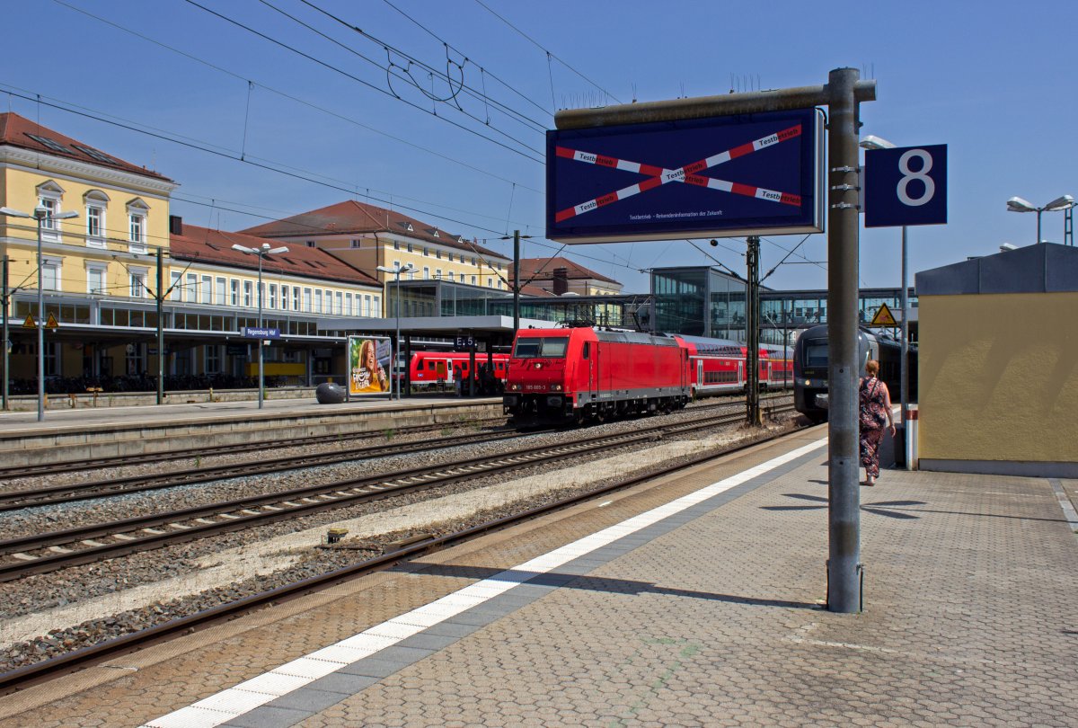 Ung�nstigerweise ist die Rheincargo-Lokomotive 185 605 als Leerfahrt gerade in dem Augenblick auf dem Durchfahrgleis in Regensburg unterwegs, als im Hintergrund die Werbe-146 ausf�hrt. Letztlich hat es aber f�r Bilder beider Lokomotiven gereicht.

Au�erdem im Bild: Die  Reisendeninformation der Zukunft , die leider keinerlei Informationen bietet. Allerdings scheint der Testbetrieb noch nicht aufgenommen worden zu sein und das System in Zukunft informativer sein.