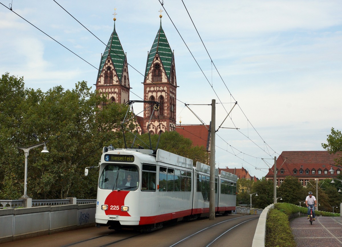 VAG: GT 8N 225 der Freiburger Verkehrs AG auf der Linie 5, kurz vor der Haltestelle Hauptbahnhof am 3. September 2015. Im Hintergrund ist die rmisch katholische Herz-Jesu-Kirche ersichtlich, die in den Jahren 1892 bis 1897 errichtet wurde. Zur Zeit verkehren auf den Strassenbahnlinien 3 und 5 noch GT 8K- und GT 8N-Wagen. 
Foto: Walter Ruetsch 