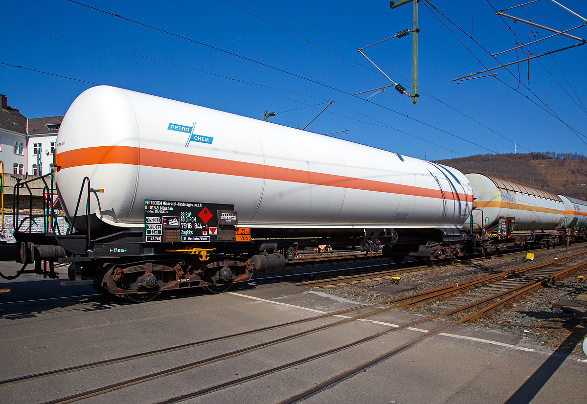 Vierachsiger Drehgestell-Druckgaskesselwagen für LPG, 33 80 7918 844-1 D-PCM, der Gattung Zagkks, PETROCHEM Mineralöl-Handelsgesellschaft m.b.H. (München) im Zugverbund am 24.03.2021 bei der Zugdurchfahrt in Niederschelden (Sieg), hier passiert er gerade den Bü 343 (Km 112,183 der Siegstrecke KBS 460).

Im allgemeinen Sprachgebrauch versteht man unter Flüssiggas oft nur LPG (von engl. Liquified Petroleum Gas), das heißt verflüssigt kurzkettige Kohlenwasserstoffgase (Gemisch C), wie Propan, Isobutan, Butan o.ä., Gefahrgutkennzeichnung 23/1965. Diese Gase bleiben bei Raumtemperatur und geringer Kompression (< 10 bar) flüssig.

TECHNISCHE DATEN (gem. Anschriften) :
Spurweite: 1.435 mm
Achsanzahl: 4 (in 2 Drehgestelle)
Länge über Puffer : 17.900 mm
Drehzapfenabstand: 12.000 mm
Achsabstand im Drehgestell: 1.800 mm
Laufraddurchmesser:  920  mm (neu)
Drehgestelle: DB Bauart 642
Höchstgeschwindigkeit: 100 km/h (beladen) / 120 km/h (leer)
Kleinster befahrbarer Gleisbogen: R 35 m
Eigengewicht: 33.980 kg
Nutzlast: 45,0 t (ab Streckenklasse C)
Gesamtvolumen: 109.200 Liter (109,2 m³)
Bremse: KE-GP (LL)
Tankcode:  P29BH 
P =Tank für verflüssigte oder unter Druck gelöste Gase
29 = Mindestberechnungsdruck 29 bar
B = Tank mit Bodenöffnungen mit 3 Verschlüssen für das Befüllen oder Entleeren 
H = luftdicht verschlossener Tank
Behälterwerkstoff: StE 460
Intern. Verwendungsfähigkeit: RIV