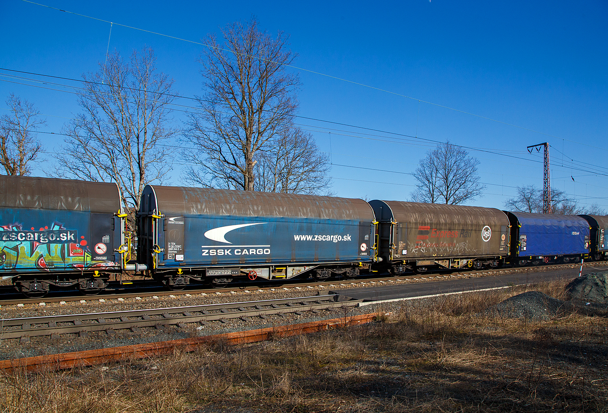 Vierachsiger Drehgestell-Flachwagen mit verschiebbarem Planenverdeck und Lademulden für Coiltransporte, 31 56 4668 244-5 SK-ZSSKC, der Gattung Shimmns, der slowakischen ZSSK Cargo (Železničná spoločnosť Cargo Slovakia), am 10.03.2022 im Zugverband bei einer Zugdurchfahrt in Rudersdorf (Kr. Siegen).