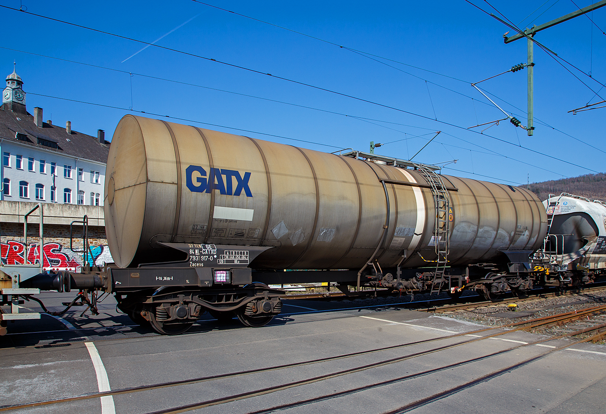 Vierachsiger-Drehgestell Kesselwagen für Düsenkraftstoff (Jet A-1), der Gattung Zacens, registriert als 37 84 7831 917-4 NL-GATXD der GATX Rail Germany GmbH, am 24.03.2021 bei der Zugdurchfahrt in Niederschelden (Sieg), hier passiert er gerade den Bü 343 (Km 112,183 der Siegstrecke KBS 460).

TECHNISCHE DATEN:
Gattung: Zacens  (GATX Typ 1278)
Spurweite: 1.435 mm
Länge über Puffer : 16.360 mm
Drehzapfenabstand: 10.820 mm
Achsabstand im Drehgestell: 1.800 mm
Laufraddurchmesser: 920 mm
Höchstgeschwindigkeit: 100 km/h (120 km/h leer)
Eigengewicht: 25.680 kg
Nutzlast: 64,3 t (ab Streckenklasse D)
Gesamtvolumen: 78.765 Liter
Bremse: KE-GP
Prüfdruck: 4,0 bar
Max. Betriebsdruck: 3,0 bar
Tankcode: L 4 BH
L= Tank für Stoffe in flüssigem Zustand (flüssige Stoffe oder feste Stoffe, die in geschmolzenem Zustand zur Beförderung aufgegeben werden)
4= zutreffender Mindestprüfdruck in bar
B = Tank mit Bodenöffnungen mit 3 Verschlüssen für das Befüllen oder Entleeren 
H = luftdicht verschlossener Tank
Intern. Verwendungsfähigkeit:  TEN-GE
