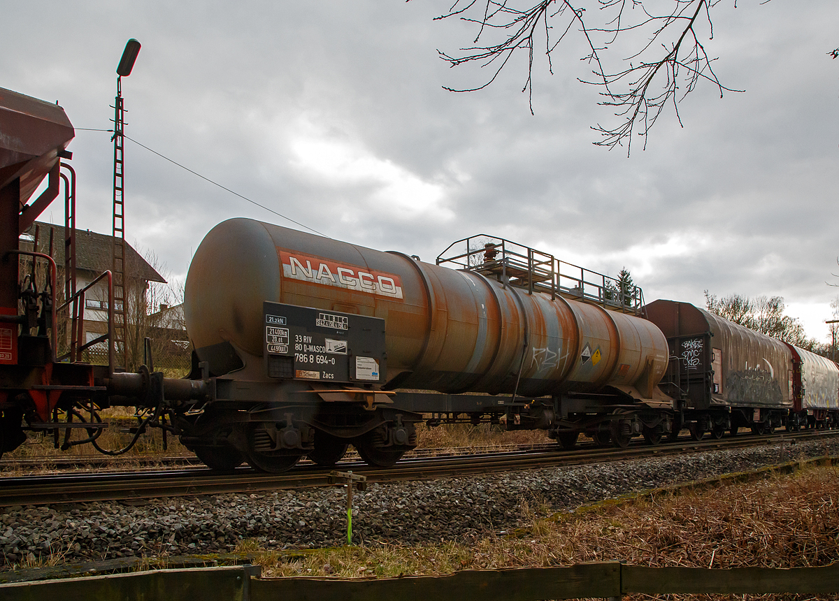 Vierachsiger-Drehgestell Kesselwagen für Salpetersäure (>98%), der Gattung Zacs, registriert als 33 80 7868 694-0 D-WASCO der WASCOSA AG, die einen Teil der NACCO Flotte übernommen hat, am 15.02.2022 in Herdorf, im Zugverband eines Übergabezuges der KSW.

Die Gefahrguttafel (885/2031) zeigt es auch noch an: (oben) Gefahrgutnummer 885 = stark ätzender Stoff / (unten) UN-Nummer 2031 = Salpetersäure, andere als rotrauchend, mit mehr als 70 % Säurebrandfördernd. Hier sogar (laut Anschrift) größer 97 %.
Die reine Säure ist farblos und hat einen scharf stechenden Geruch. Sie wird unteranderem zur Herstellung von Sprengstoffen verwendet, was hier der Fall ist.

TECHNISCHE DATEN:
Gattung: Zacs
Spurweite: 1.435 mm
Länge über Puffer : 14.240 mm
Drehzapfenabstand: 9.200 mm
Achsabstand im Drehgestell: 1.800 mm
Höchstgeschwindigkeit: 100 km/h 
Eigengewicht: 21.400 kg
Nutzlast: 58,6 t ab Streckenklasse C
Gesamtvolumen: 44.900 Liter
Prüfdruck: 4 bar
Zulässiger Betriebsüberdruck: 3 bar
Tankcode: L10DH
Behälterwerkstoff : Edelstahl
Bremse: KG-GP
Intern. Verwendungsfähigkeit: RIV