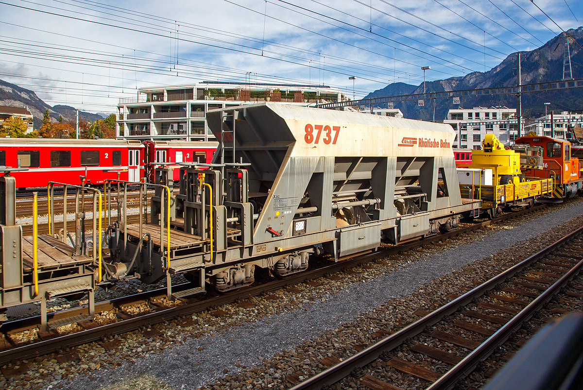 Vierachsiger Schmalspur Drehgestell-Schotterwagen (Schwerkraftentladewagen) Xac der Serie 8726 – 8742 (hier Xac 8737, ex Fac 8737)  eingereiht in einen Bauzug am 01.11.2019 im Rbf Chur (aufgenommen aus einem Zug Heraus). Diese Wagen wurden 1997 von der Firma Josef Meyer in Rheinfelden gebaut, spter erfolgte ein Umbau zum Dienstwagen Xac 8737.

Mit den Schwerkraftentladewagen transportiert die RhB problemlos Ihre Schttgter wie Kies, Sand etc. auf der Schiene durch Graubnden. Ein rascher Verlad und Entlad spart Zeit und Geld und mit 33 – 34 Tonnen Ladung ist es eine gewichtige Alternative zum Straentransport.

TECHNISCHE DATEN:
Spurweite: 1.000 mm
Lnge ber Puffer: 12.500 mm
Breite ber Alles: 2.550 mm
Hhe ber SOK: 3.360 mm
Drehzapfenabstand: 7.000 mm 
Achsabstand im Drehgestell: 1.400 mm
Laufraddurchmesser: 750 mm (neu)
Breite der Entladeffnungen: 2 x 1.232 mm
Eigengewicht: 15.490 kg
Ladegewicht: max. 33 t
Ladevolumen: 22 m
