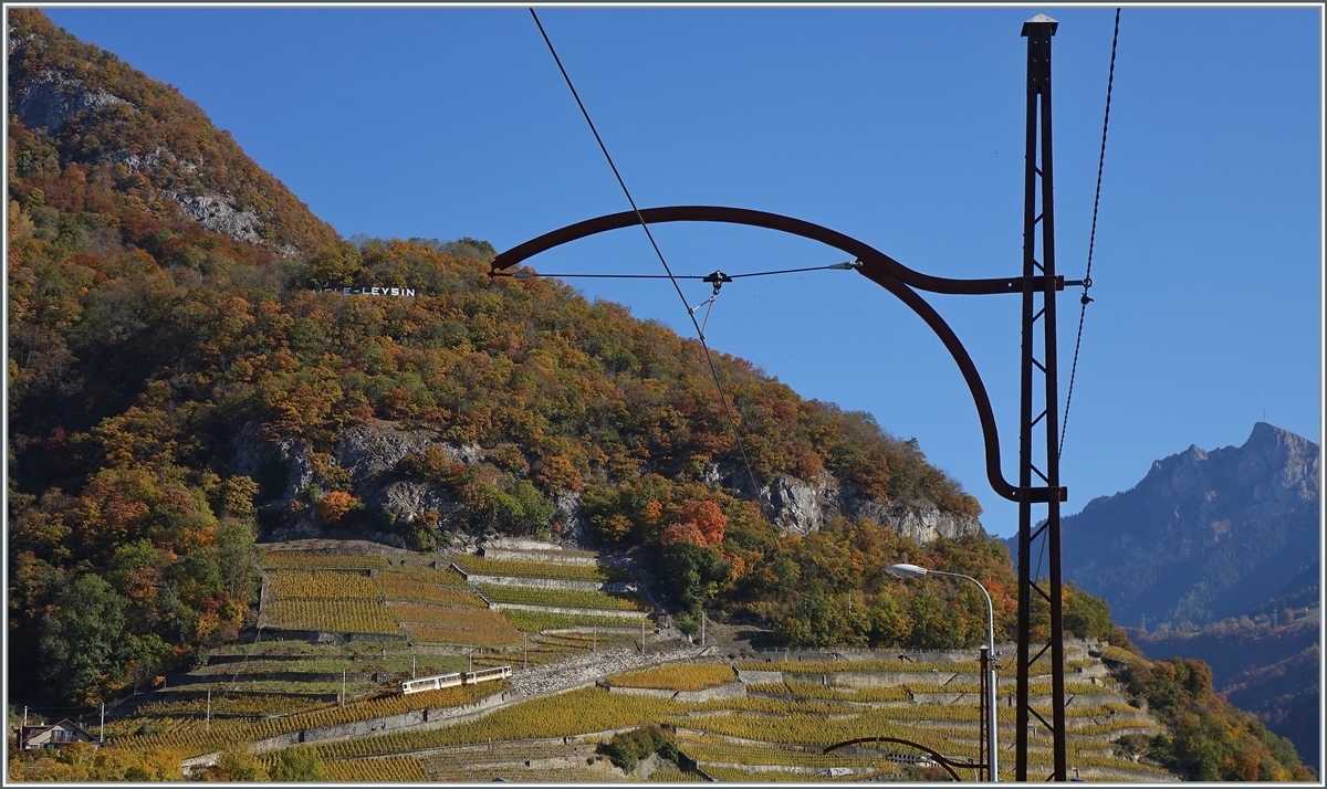 Von einem Fahrleitungsmast der ASD eingerahmt, ist ein A-L Zug in den Weinbergen oberhalb von Aigle unterwegs. 

27. Okt. 2021