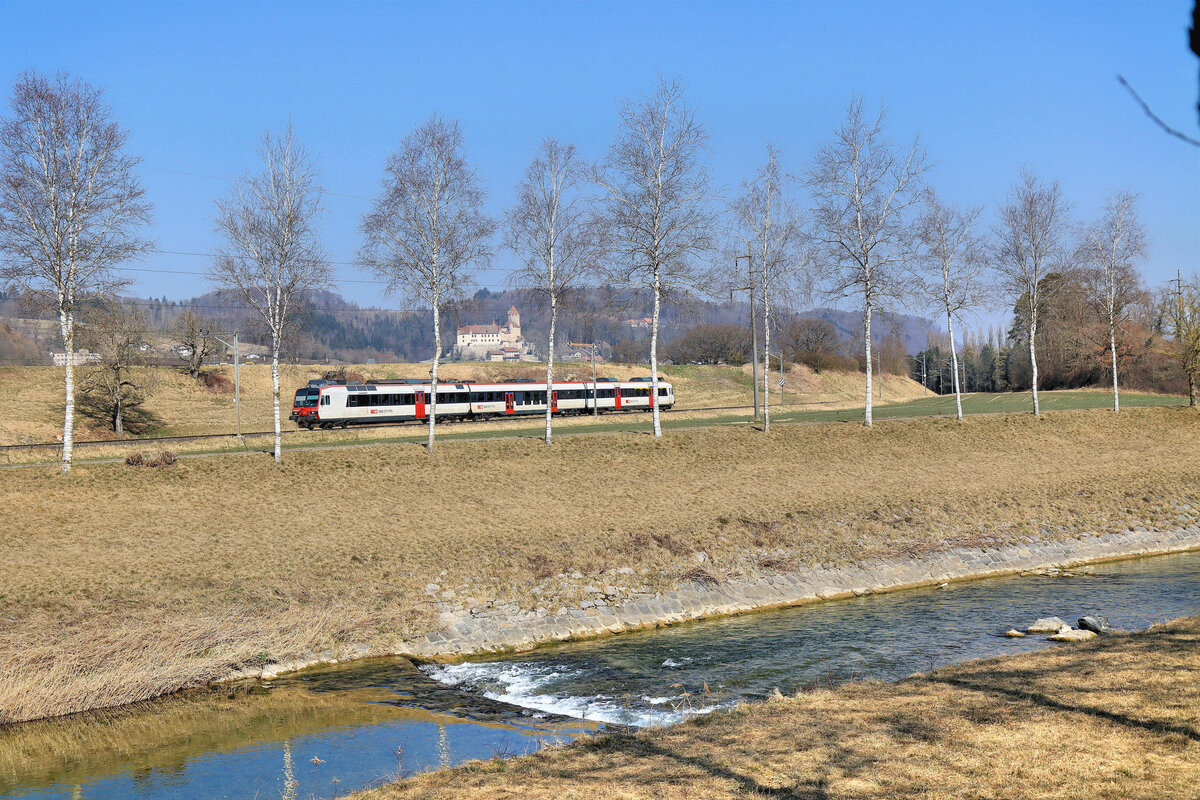Vor dem Château de Lucens im Hintergrund kommt eine S9 als Domino-Zug Richtung Moudon - Palézieux hervor. 10.März 2022 