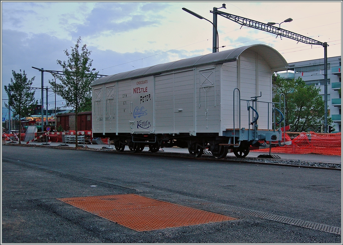 Vor Jahren nutzten die Industriebetriebe, die gleich nördlich des Bahnhofs Vevey lagen, ein durch eine Drehschiebe mit dem Bahnhof verbundenes Anschlussgleis. Nun sind die erwähnten Industiebetriebe durch ein Wohnquartier ersetzt worden und das ohnhin seit Jahren ungenutzte Anschlussgleis entgültig überflüssig. Doch interessanterweise hat man das Normalspurgleis aus dem Aspalt herausgearbeitet, ein kleines Stück mit einem Meterspurgleis versehen und nun einen GFM K3 Güterwagen zur Erinnerung hingestellt. Nestlé sei Dank. 27. Mai 2016