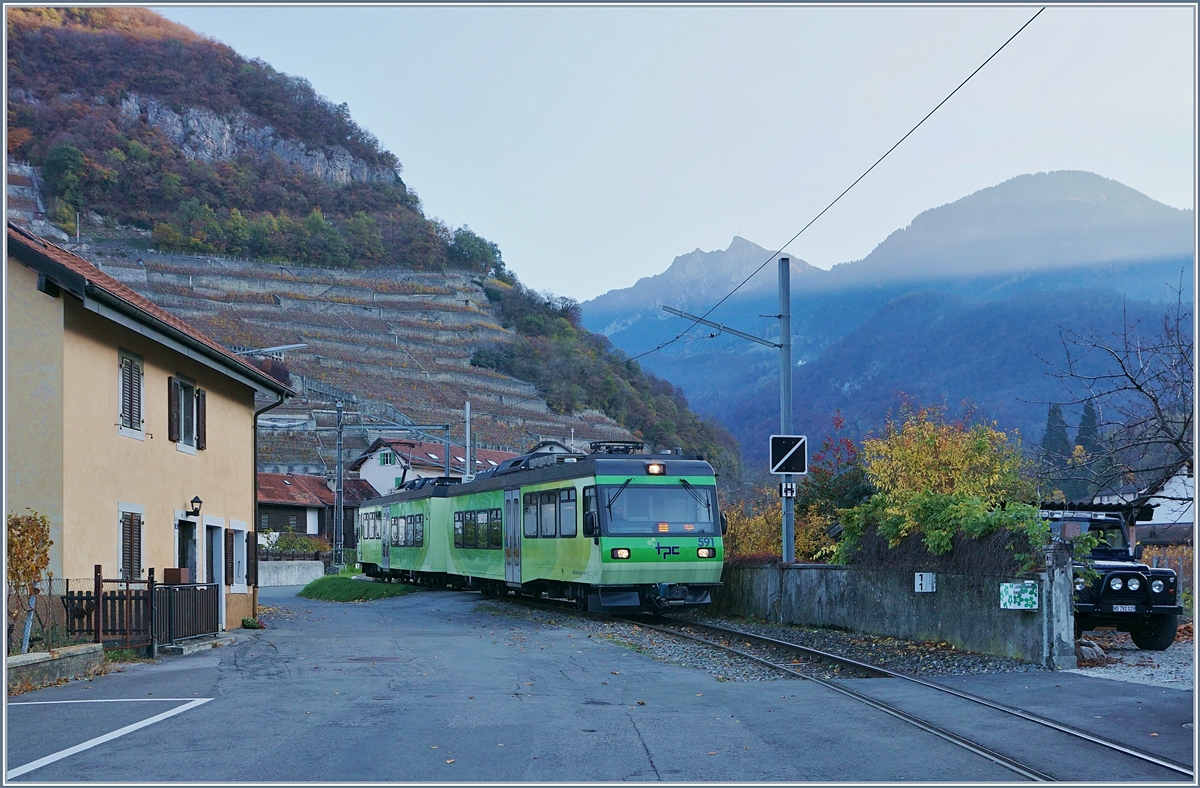 Während auf dem Berg schon die ersten Sonnenstrahlen angekommen sind verlässt im schattigen Tal kurz nach dem Bahnhof Aigle Château (vormals: Aigle Dépôt ASD) der TPC Beh 4/8 591 das ASD Eigentrasse und wird nun auf der Strasse die restlichen 1.1 Kilometer bis zum Bahnhof Aigle fahren. 
8. Nov. 2018