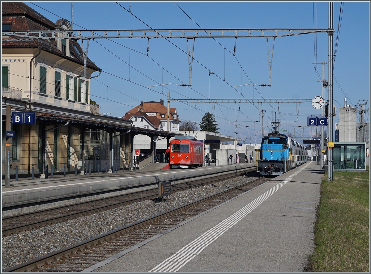 Während rechts im Bild der Stadler Eea 936 133-8 mit einem sechsteiligen Westbahn  Kiss 2  auf dem Weg in Richtung St. Margrethen in Rheineck durchfährt, wartet links im Bild der der AB RhW BDeh 1/2  auf die Abfahrt nach Walzenhausen. 23. März 2021

23. März 2021