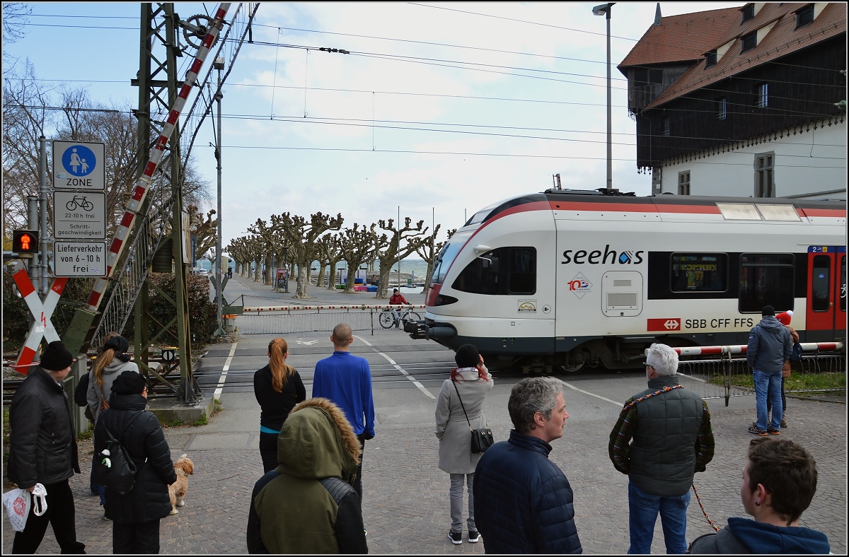 Während einer der vielen Bahnübergangsstörungen in Konstanz bleiben die Passanten in respektvollem Abstand zum Seehas und sind erstaunt über den freien Blick. RABe 521 209-0 am Konzil in Konstanz, März 2016.