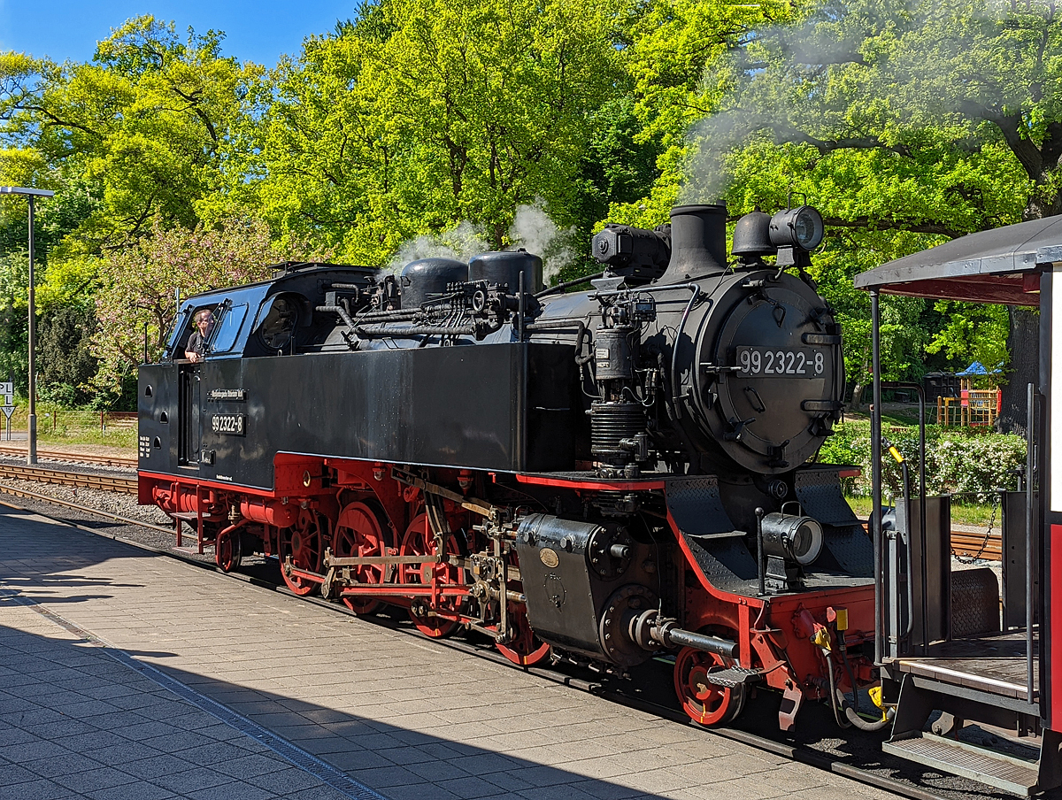 Was heute für Bilder mit dem Smartphone möglich sind....
Die 99 2322-8 der Mecklenburgischen Bäderbahn Molli steht am 15.05.2022 mit dem MBB Dampfzug nach Kühlungsborn-West im Bahnhof Bad Doberan zur Abfahrt bereit.

Die 900 mm-Schmalspur-Dampflok der DR-Baureihe 99.32 wurde1932 von O&K - Orenstein & Koppel AG in Berlin-Drewitz unter der Fabriknummer 12401 gebaut und an die DRG - Deutsche Reichsbahn-Gesellschaft als 99 322, für die Bäderbahn Bad Doberan–Kühlungsborn, geliefert.

Lebenslauf
1932 	bis 1970 DRG, DRB bzw. DR 99 322
01.06.1970 Umzeichnung in DR 99 2322-8 
01.01.1992 Umzeichnung in DR 099 902-9
01.01.1994 DB 099 902-9 
Seit dem 04.10.1995 Mecklenburgische Bäderbahn Molli GmbH, Bad Doberan MBB 99 2322-8

Die Fahrzeuge der Baureihe 99.32 der Deutschen Reichsbahn sind nach den Einheitsgrundsätzen gebaute Schmalspur-Lokomotiven für die Spurweite von 900 mm. Die 1932 für die Bäderbahn Bad Doberan - Kühlungsborn beschafften drei Lokomotiven sind bis heute im Einsatz und werden durch eine 2009 von dem Dampflokwerk Meiningen nachgebaute Lokomotive dabei ergänzt.

Das steigende Verkehrsaufkommen auf der Bahnstrecke zwischen Bad Doberan und Kühlungsborn führte die 1923 beschafften Lokomotiven der Baureihe 99.31 an ihre Leistungsgrenze. Die Deutsche Reichsbahn bestellte deshalb bei Orenstein & Koppel drei Lokomotiven der Bauart 1'D1' h2 zur Erweiterung des Fahrzeugparks. Dabei sollte sich das Unternehmen bei der Konstruktion an die Baugrundsätze und Normen der Einheitslokomotiven orientieren. Ursprünglich waren die Lokomotiven im Typen-Programm nicht vorgesehen. Die Verwendung vieler standardisierter Baugruppen erlaubt jedoch die Verwendung des Begriffs Einheitslokomotive. Die drei Lokomotiven wurden 1932 ausgeliefert. Zur Verkürzung der Reisezeit wurden die Fahrzeuge für eine Geschwindigkeit von 50 km/h ausgelegt. Damit sind sie neben der NWE Nr. 21 (HSB 99 6001) die einzigen deutschen Schmalspurdampflokomotiven mit einer solchen Höchstgeschwindigkeit.

Mit der Einführung der EDV-Nummern erhielten die Lokomotiven 1970 die neue Loknummern 99 2321-0, 99 2322-8 und 99 2323-6. In der Mitte 1970er Jahre erhielten die 99 2322 und 99 2323 geschweißte Stahlzylinder statt der abgenutzten Graugusszylinder. Bei der 99 2321 erfolgte der Tausch Ende der 1980er Jahre. Mit der Einführung des Nummernschemas der Deutschen Bundesbahn zum 1. Januar 1992 erhielten die Lokomotiven die Betriebsnummern 099 901-1, 099 902-9 und 099 903-7. Mit der Betriebsübernahme der Mecklenburgischen Bäderbahn Molli GmbH & Co. KG zum 1. Oktober 1995 kamen die Lokomotiven zu dieser Gesellschaft und erhielten ihre vorherigen EDV-Nummern zurück.

Zwischen 1994 und 1997 wurden alle Lokomotiven im Dampflokwerk Meiningen einer Generalinstandsetzung unterzogen. Dabei erhielten die Lokomotiven geschweißte Kessel, neue Wasserkästen und Radreifen. Bei der Hauptuntersuchung im Zeitraum 2003 bis 2006 erhielten die Lokomotiven neue geschweißte Blechrahmen. An der 99 2322-6 erprobte man von 2003 bis 2006 Rollenachslager. Diese bewährten sich jedoch nicht.

Da die noch betriebsfähige Lokomotive der Baureihe 99.33 (99 331) den Anforderungen des Sommerfahrplans nicht gewachsen ist, aber eine weitere leistungsfähige Lok benötigt wurde, entschloss man sich, eine Lokomotive der Baureihe 99.32 auf der Basis der bisherigen konstruktiven Verbesserungen nachzubauen. Die im Dampflokwerk Meiningen hergestellte Lokomotive 99 2324-4 wurde 2009 in Dienst gestellt.

Konstruktive Merkmale:
Abweichend von den Bauprinzipien der Einheitslokomotiven verfügten die Lokomotiven über einen genieteten Blechrahmen mit Längs- und Querversteifungen statt eines Barrenrahmens. Seit der von 2003 bis 2006 durchgeführten Hauptuntersuchung besitzen die Lokomotiven einen geschweißten Blechrahmen.

Der genietete Langkessel besteht aus zwei Schüssen. Der Dampfdom mit dem Schmidt & Wagner-Nassdampfregler sitzt auf dem zweiten Schuss, während der Sandkasten auf dem ersten sitzt. Der für Nass- und Heißdampf getrennte Dampfsammelkasten befindet sich in der Rauchkammer. Beim Rauchrohrüberhitzer verwendet man einen ungewöhnlichen Rohrspiegel. Vier Heizrohren stehen 69 Rauchrohre gegenüber. Die Ackermann-Sicherheitsventile sitzen auf dem Stehkesselscheitel. 1994 bis 1997 erhielten die Lokomotiven neu konstruierte geschweißte Stahlkessel.

Das außenliegende waagerecht angeordnete Zweizylinder-Heißdampftriebwerk arbeitet auf die dritte Kuppelachse. Die ursprünglichen Graugusszylinder wurden ab Mitte der 1970er Jahre durch geschweißte Stahlzylinder ersetzt. Die außenliegende Heusinger-Steuerung besitzt eine Kuhnsche Schleife. Die ursprünglichen Regelkolbenschieber wurden später durch Müller-Druckausgleich-Kolbenschieber ersetzt. Heute kommen Trofimoff-Schieber der Bauart Görlitz zur Anwendung.

Das Laufwerk ist an vier Punkten abgestützt. Die Blattfederpakete der Kuppelradsätze liegen unterhalb der Achslager. Die Laufradsätze werden oberhalb der Achslager abgefedert. Die Federn der beiden äußeren Radsätze sowie des benachbarten Laufradsatzes sind jeweils durch Ausgleichshebel verbunden. Die Laufradsätze sind als Bisselachsen mit 20 mm Seitenverschiebbarkeit ausgelegt. Die dritte Kuppelachse hat eine Spurkranzschwächung.

Als Lokomotivbremse dient eine Knorr-Zweikammer-Druckluftbremse. Alle Kuppelräder werden von vorn gebremst. Die Luftpumpe befindet sich rechts neben der Rauchkammer. Die Luftbehälter befinden sich auf beiden Seiten unter dem hinteren Wasserkasten.

Die Borsig-Druckluftsandeinrichtung sandet bei Vorwärtsfahrt die ersten beiden Radsätze und bei Rückwärtsfahrt die zweite und dritte Achse. Zur besseren Sicherung der Zugfahrt verfügten die Maschinen über ein Knorr-Druckluftläutewerk vor dem Schornstein und auf dem Kohlekasten. Wegen Lärmbeschwerden der Anwohner bei der Stadtdurchfahrt von Bad Doberan wurde das hintere Läutewerk später entfernt. Ein Dampfturbogenerator hinter dem Schornstein erzeugt eine Leistung von 5 kW bei 85 V. Die Lokomotive verfügt über eine Dampfheizungsanlage.

Das Kesselwasser ist in Wasserkästen vor dem Führerhaus entlang des Langkessels untergebracht. Der Kohlevorrat befindet sich in einem Kohlekasten hinter dem Führerhaus.

Auf Grund des eingeschränkten Lichtraumprofils musste der obere Teil des Führerhauses stark abgeschrägt werden.

TECHNISCHE DATEN:
Anzahl: 	4
Hersteller: Orenstein & Koppel, DLW Meiningen
Baujahre: 1932, 2008
Bauart: 1’D1’ h2t
Gattung: K 46.8
Spurweite: 	900 mm
Länge über Puffer: 10.595 mm
Höhe: 3.400 mm
Gesamtradstand: 8.075 mm
Leergewicht: 35,15 t
Dienstgewicht: 43,68 t
Höchstgeschwindigkeit: 50 km/h
Indizierte Leistung: 460 PSi / 338 kW
Anfahrzugkraft: 59,33 kN
Kuppelraddurchmesser: 1.100 mm
Laufraddurchmesser: 550 mm (vorn und hinten)
Steuerungsart: 	Heusinger außenliegend
Zylinderanzahl: 	2
Zylinderdurchmesser: 380 mm
Kolbenhub: 550 mm
Kesselüberdruck: 14 bar
Anzahl der Heizrohre: 4
Anzahl der Rauchrohre: 69
Heizrohrlänge: 3.500 mm
Rostfläche: 1,60 m²
Strahlungsheizfläche: 5,80 m²
Rohrheizfläche: 54,74 m²
Überhitzerfläche: 30,60 m²
Verdampfungsheizfläche: 60,54 m²
Wasservorrat: 4,25 m³
Brennstoffvorrat: 1,7 t Kohle
Lokbremse: Knorr-Zweikammer-Druckluftbremse
Zugheizung: Dampf
