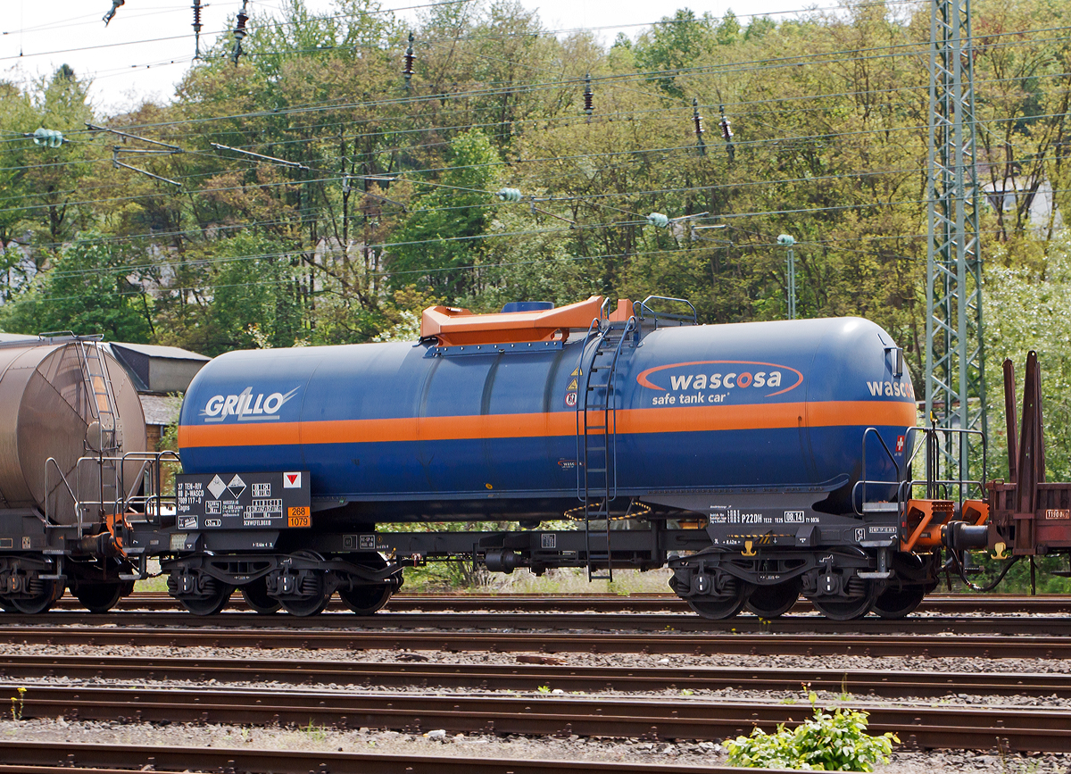 WASCOSA vierachsige Kesselwagen (54 m3) der Bauart Zagns (37 80 7809 117-0 D-WASCO) fr/beladen mit Schwefeldioxid (der Grillo-Werke AG), Gefahrgut-Nr. 268/1079, bei der Fahrt im Zugverbund am 17.05.2012 durch Betzdorf/Sieg.

Ausgefhrt als WASCOSA safe tank car. Die WASCOSA AG ist ein Schweizer Wagonvermieter.

Der WASCOSA safe tank car setzt einen neuen Sicherheits-Mastab im Transport von Gefahrgut auf der Schiene. Eine erste Serie des WASCOSA safe tank car wird fr den Transport von Schwefeldioxid eingesetzt. Mit seinen verschiedenen Sicherheitselementen und den optimierten bergangsbhnen an beiden Wagenenden verkrpert dieser Wagentyp den Gefahrgutkesselwagen der Zukunft. Gemeinsam mit dem Kunden, Gterwagen- und Komponentenherstellern, Know-how-Trgern der Crash- und Simulations-Technologie sowie nicht zuletzt dem deutschen Eisenbahn-Bundesamt wurde ein vllig neues Sicherheits- und Arbeitsschutzpaket entwickelt.

Zu den Sicherheitskomponenten gehrt zum Beispiel ein vllig neuer, zum Patent angemeldeter berrollschutz. Ein weiteres Sicherheitselement sind die aus dem Lokomotivbau stammenden EST Suprapuffer G2. Das nach neuesten Erkenntnissen optimierte Kraftniveau und Deformationsverhalten dieser Puffer schtzt den Wagen mit verstrktem Untergestell weit ber das im RID geforderte Ma hinaus.

Um grere Schden bei Entgleisungen zu vermeiden, ist der Wagen mit zwei mechanischen Entgleisungsdetektoren ausgerstet. Zustzlich ist der Kesselwagen mit vier Aufkletterschutz-Modulen Typ AC04 der Firma EST ausgerstet, welche bei einem Unfall das Aufklettern der Puffer eines Wagens ber die Puffer des benachbarten Wagens verhindern. Erstmals erfllt dieser vllig neu konzipierte berpufferungsschutz die RID-Sondervorschrift TE25 Absatz a), die nicht nur fordert, den Kesselboden vor dem Eindringen von aufkletternden Gegenpuffern zu schtzen, sondern das Entstehen von Aufklettern bereits in der Anfangsphase zu verhindern.

Zur Arbeitssicherheit trgt eine optimierte bergangsbhne mit durchgehend uneingeschrnkter Arbeitsgangbreite und zustzlichen Handgriffen am seitlichen Aufstieg bei. Wurde bei Neubau bisher nur ein Wagenende mit einer bergangsbhne ausgestattet, so bietet der WASCOSA safe tank car dem Betriebspersonal an beiden Wagenenden eine sichere bergangs- und Mitfahrmglichkeit.

Technische Daten:
Eigengewicht: 24.850 kg
Lnge ber Puffer: 13.460 mm
Drehzapfenabstand: 8.420 mm
Achsabstand im Drehgestell: 1.800 mm
Puffer EST Suprapuffer G2 - 100 MB
Drehgestelle: Y25 Lsd mit  K -Verbundsstoffbremsklotzsohlen
Radstze/Lagergehuse: BA 004/182
Bremse: KNORR KE-GP A
Hchstgeschwindigkeit: 120 km/h leer / 100 km/h beladen
Tankinhalt: 54 m3 (54.000 l)
Tankcode: P22DH, mit Sondervorschriften TE 22 und TE 25
P= Tank fr verflssigte oder unter Druck gelste Gase
22 = zutreffender Mindestprfdruck in bar
D = Tank mit obenliegenden ffnungen ohne ffnungen unterhalb des Flssigkeitsspiegels
H = luftdicht verschlossener Tank
Tankwerkstoff: Feinkornbaustahl P460 NL1