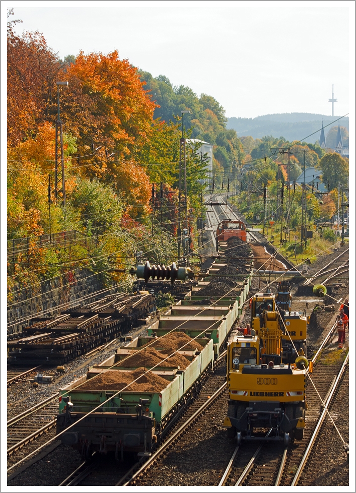 Weichenerneuerung am 19.10.2013 in Siegen-Weidenau an der KBS 440 (Ruhr-Sieg-Strecke) bei km 104 am Abzweig der KBS 445 (Dillstrecke), die hier nach links abzweigt. Ein Zweiwege-Bagger hebt den Altschotter aus und verld diesen auf die Seitenkippwagen, die die KSW Lok 42 (MaK 1700 BB) am Haken hat.