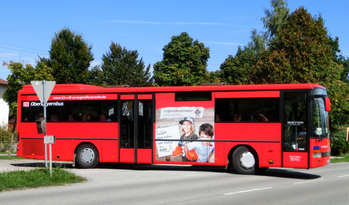 Wie mehrere Busse seiner Flotte hat Hinmüller Reisen aus Oberflossing bei Polling diesen Setra S 315 UL im Design der RVO / DB Oberbayernbus gestaltet und mit einer Werbefolie der Jugendfeuerwehr versehen. Dieses Exemplar ist bei Setra im Jahr 2000 vom Band gelaufen und hat 55 Fahrgastsitzplätze (mit kippbarer Sitzbank am Mitteleinstieg; Setra-Überlandbestuhlung Modell Special-Class mit Sicherheitsgurten) plus 2 Reiseleitersitze. Vorne, rechts und hinten ist jeweils eine LAWO-Matrix eingebaut. Der Antriebsstrang besteht aus dem Reihensechszylinder Typ MB OM 447 hLA mit 184 kW (250 PS) und dem Sechsgang-Handschaltgetriebe ZF S 6-85.
Abgelichtet wurde der Bus am Mittag des 17. 9. 2015 an der Wendeschleife vor der Inn-Apotheke in Kraiburg/Inn, als er aus Waldkraiburg kommend auf der RBO-Linie 6224 Kurs 034 unterwegs war.