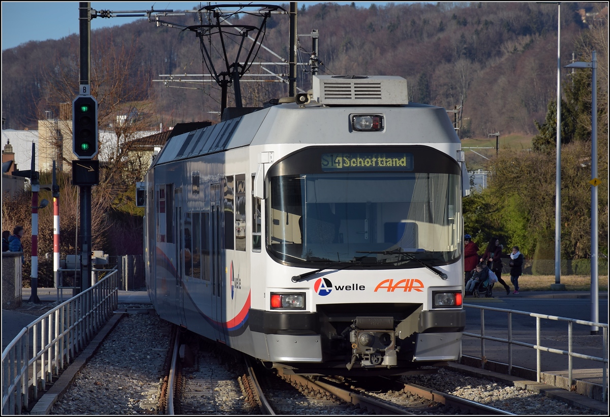 Wynentalbahn, ab etwa hier in Reinach verläuft die Strecke der Wynentalbahn nunmehr auf dem Trassée der ehemaligen Normalspurbahn von Beinwil nach Beromünster. Ein  mit Triebzug der neuesten Generation fährt aus Richtung Aarau. Dezember 2016.