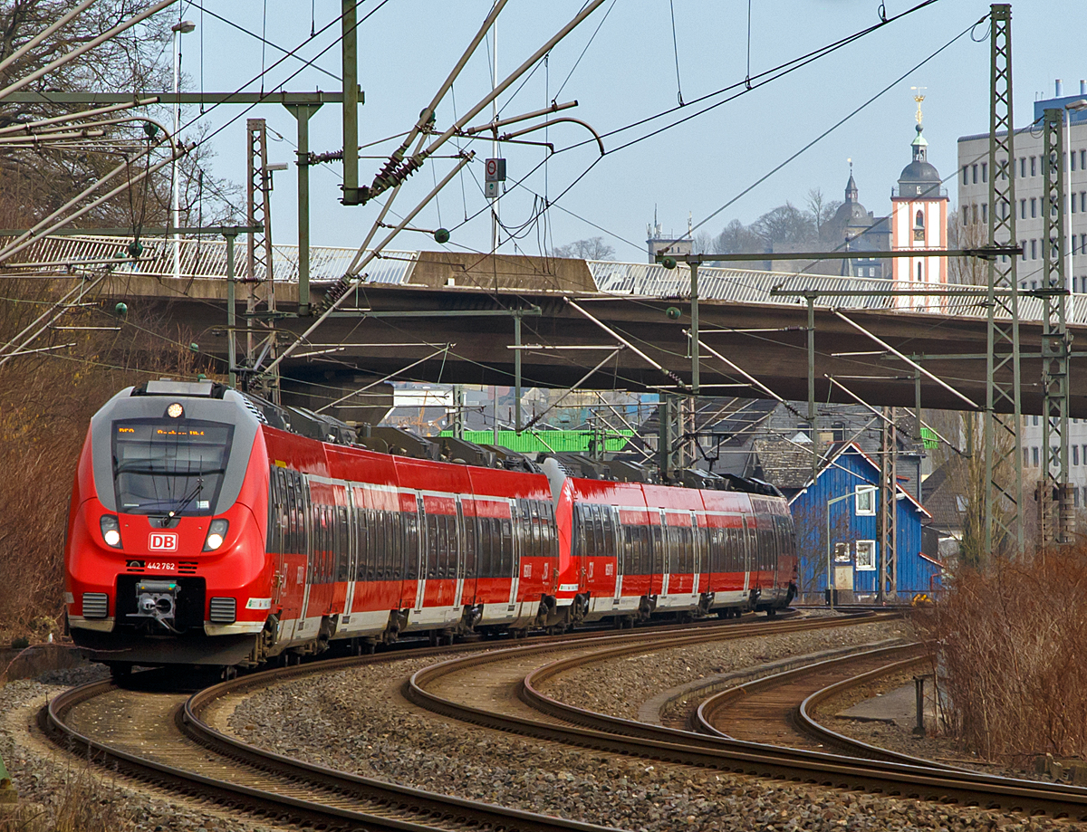 
Zwei gekoppelte 4-teilige Bombardier Talent 2 haben gerade (am 14.02.2015), als RE 9 (rsx - Rhein-Sieg-Express) Siegen - Köln - Aachen, den Hbf Siegen in Richtung Köln verlassen. 

Gut zu erkennen ist auch der (rot-weiße) Kirchturm der evangelischen Nikolaikirche, auf seiner Spitze befindet sich das Wahrzeichen der Stadt Siegen, das Krönchen. 

Das Krönchen ist ein Geschenk von Fürst Johann Moritz zu Nassau-Siegen an die Stadt Siegen und ihre Bürger. Der Anlass für das Geschenk war die Erhebung von Johann Moritz in den Fürstenstand im Jahre 1652. Der Fürst ließ die Skulptur auf eigene Kosten anfertigen und seit 1658 ziert es die Spitze des Kirchturms. Von seiner Residenz dem Oberen Schloss (links vom Turm) konnte er darauf schauen.
