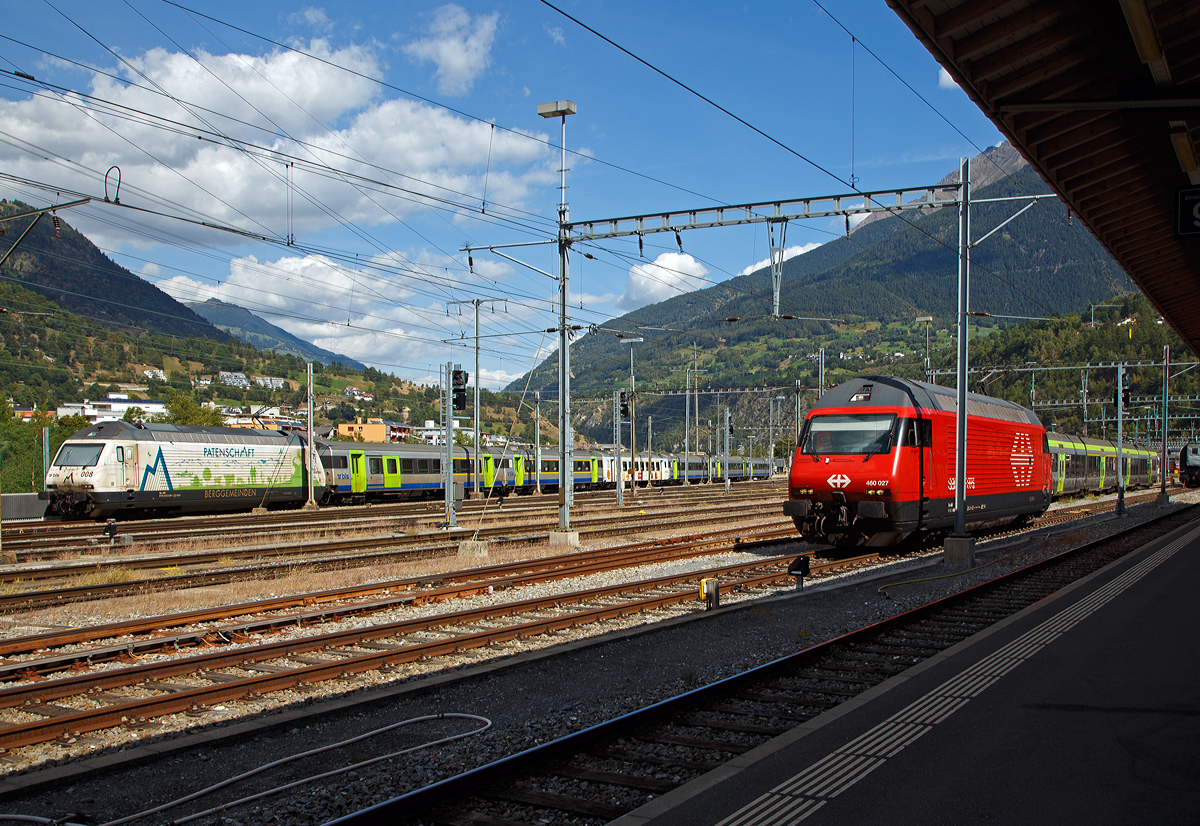 Zwei Geschwister aus der Lok-2000-Familie am 07.09.2021 im Bahnhof Brig:
Hinten links die BLS Werbelok Re 465 008-1  Allegra   (ex Niederhorn) mit Werbung Patenschaft für Berggemeinden und vorne rechts die SBB Re 460 027-6 „Joggeli“.