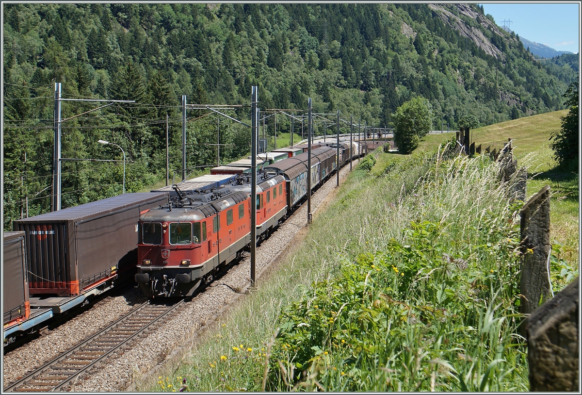 Zwei Re 4/4 II schleppen bei Rodi Fiesso einen Güterzug nordwärts, während auf dem Gegengleis ein Güterzug südwärts rollt.
24. Juni 2015