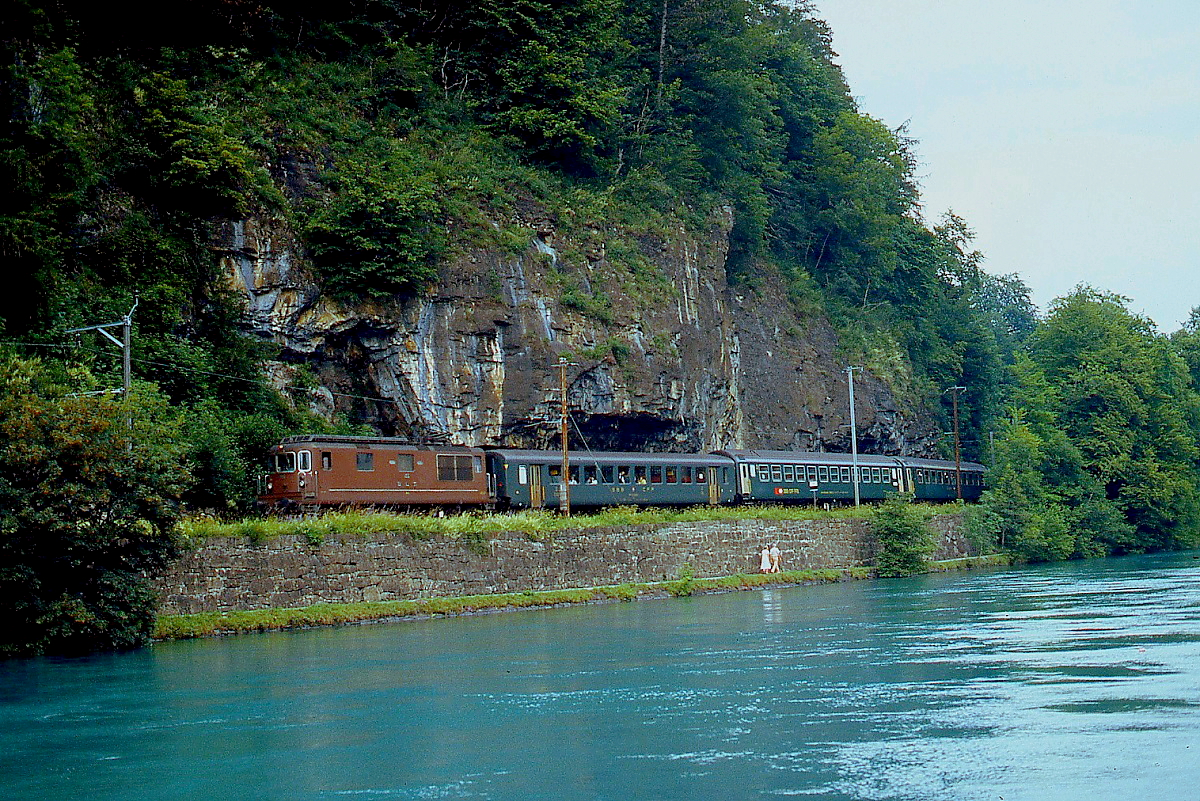 Zwischen den Bahnhöfen Interlaken Ost und West ist eine unbekannte Re 4/4 der BLS im Juni 1990 unterwegs