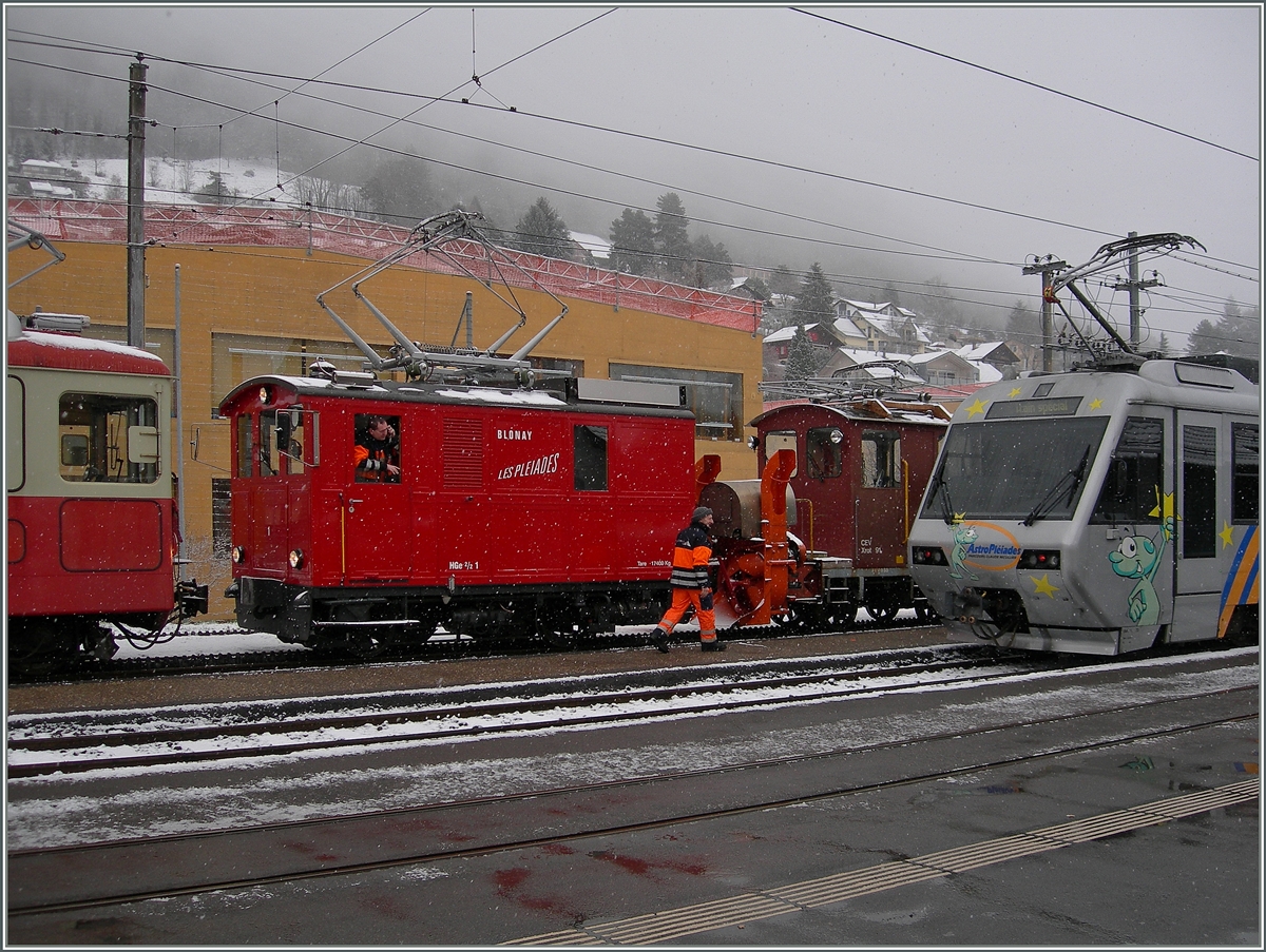 Zwischen bunten Zügen ein etwas verdeckter Blick auf den CEV Schneeräumzug mit HGe 2/2 N° 1 und Xrot 91.
Blonay, den 3. März 2016
