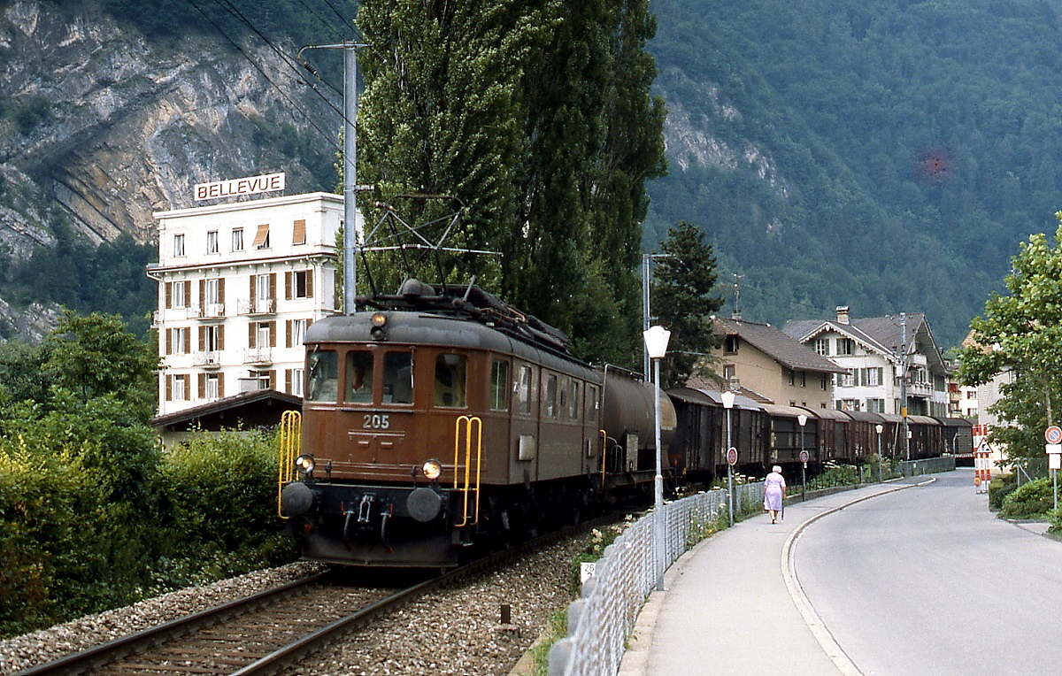 Zwischen Interlaken Ost und Interlaken West ist Ae 6/8 205 im Juni 1990 mit einem Güterzug unterwegs