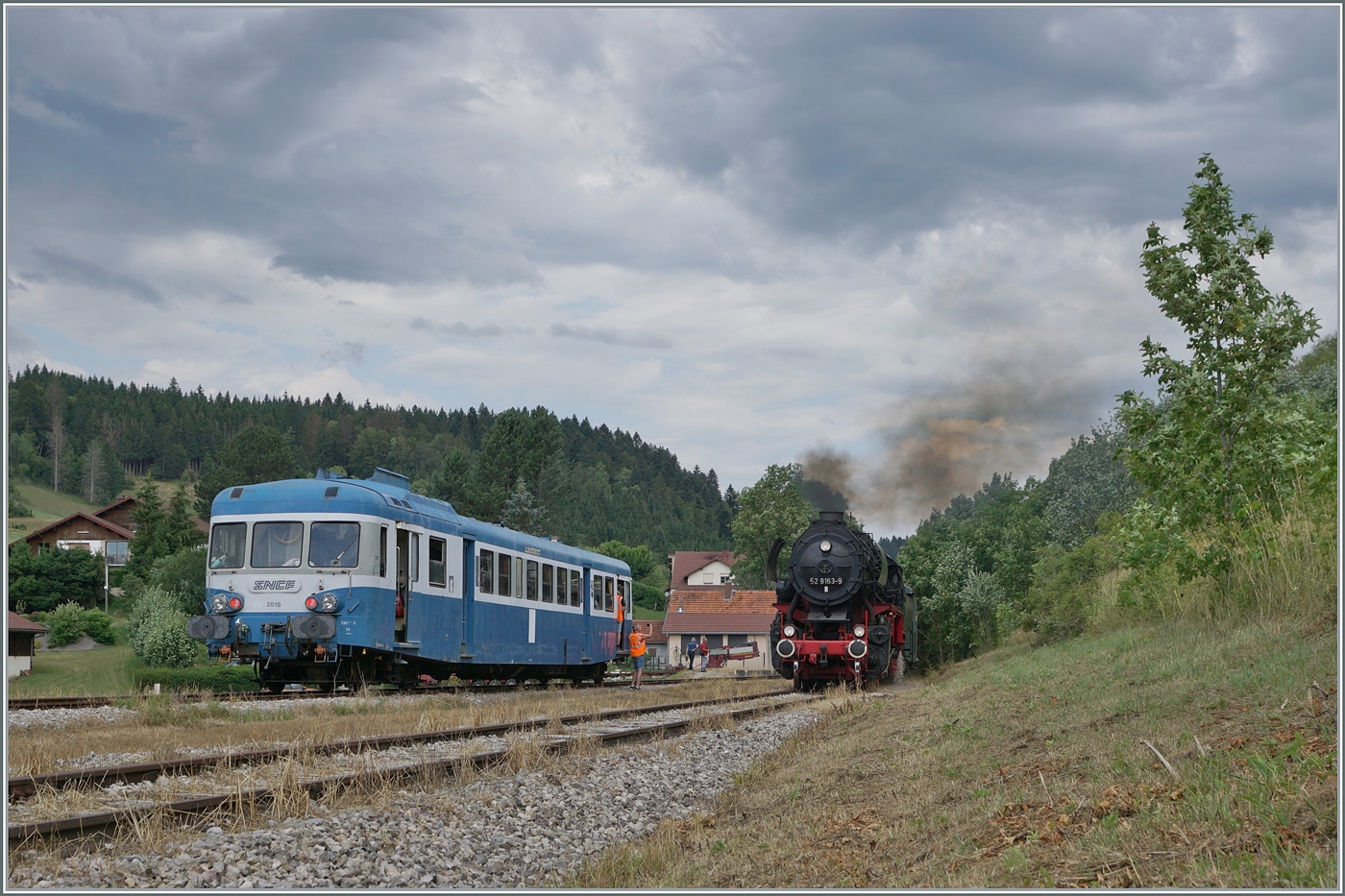 30 ANS CONI'FER /30 Jahre Coni'Fer - So viel Verkehr gab es wohl hier seit gut 110 Jahren nicht mehr! Der X 2816 der Association l'autorail X2800 du Haut-Doubs wartet im mir bis anhin unbekannten Kreuzungsbahnhof der Coni'Fer von Le Touillon auf den von der 52 8163-9 geführten Gegenzug.

15. Juli 2023