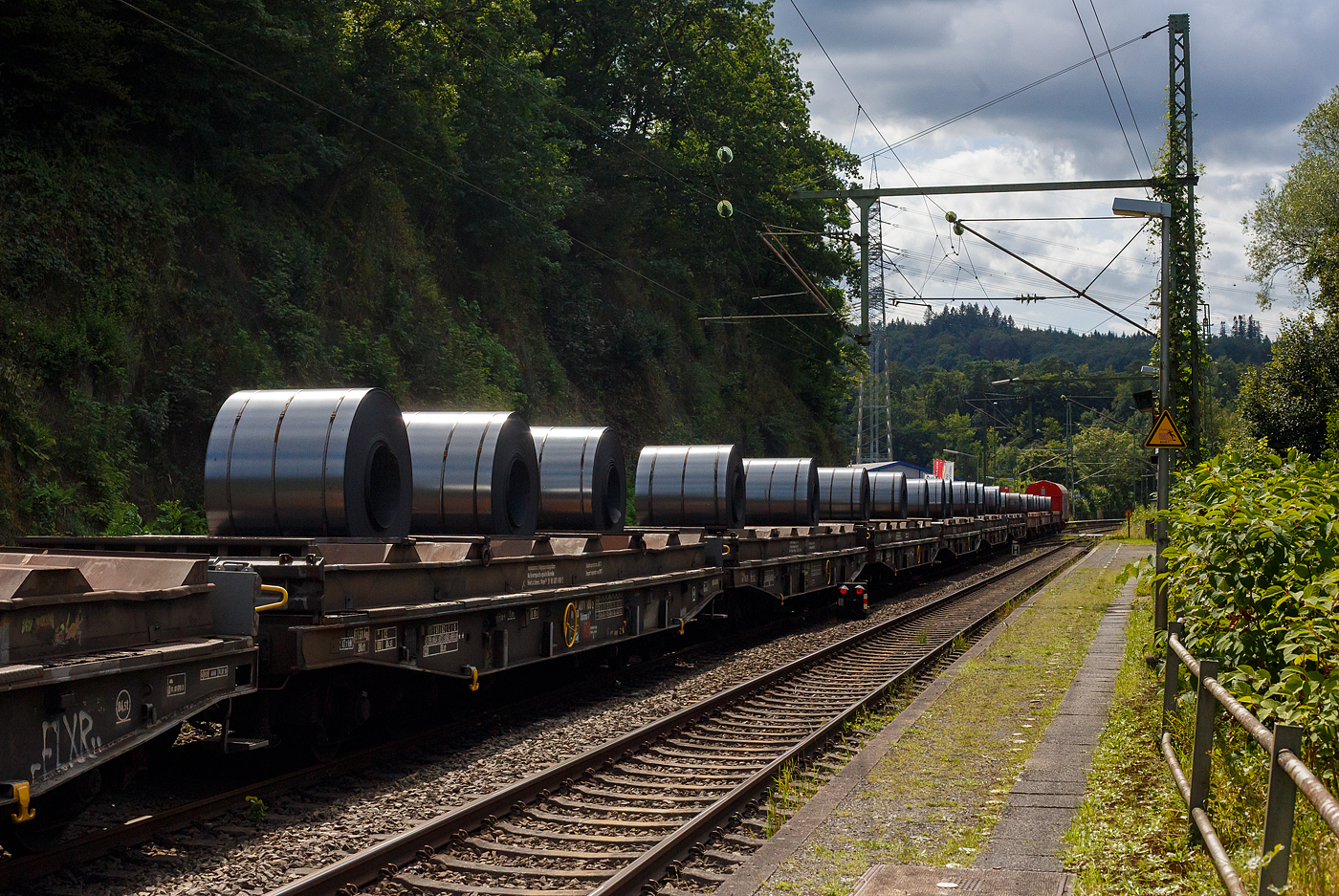 6-achsige Drehgestell-Flachwagen mit Lademulden für Coils (Blechrollen), hier im Vordergrund 31 80 4871 100-2 D-DB, der Gattung Sahmms-t 710, der DB Cargo Deutschland AG, am 08 August 2024 im Zugverband bei der Zugdurchfahrt in Scheuerfeld(Sieg), hier beladen mit 3 Warmband-Coils. 

Auf den eigentlichen Drehgestell-Flachwagen ist ein Ladegestell aufgesetzt, im dem sich 7 Lademulden für Coils befinden. Bei Bedarf kann das Ladegestell abgehoben werden und der Wagen kann so für andere Güter verwendet werden, dann würde der Wagen zur Gattung Samms 710. Früher wurden diese Wagen als Ssylms bzw. Sas 710 bezeichnet.

TECHNISCHE DATEN:
Spurweite: 1.435 mm (Normalspur)
Anzahl der Achsen: 6 in zwei Drehgestellen
Länge über Puffer: 16.400 mm
Drehzapfenabstand: 8.400 mm
Achsabstand im Drehgestell: 3.400 mm (2 × 1.700 mm)
Gesamter Radsatzstand: 11.800 mm
Ladelänge: 15.000 mm
Ladebreite in den Mulden (Sahmms-t): 2.450 mm
Max. Coil-Ø: 2.200 mm
Höchstgeschwindigkeit: 100 km/h (beladen) /120 km/h (leer)
Maximales Ladegewicht: 84,5 t (Streckenklasse CE oder höher) / Intern. 69,5 t (ab Streckenklasse D)
Eigengewicht: 35.370 kg
Achslast: 20 t
Kleinster bef. Gleisbogenradius: 80 m
Bauart der Bremse: KE-GP
Handbremse: Fbr
