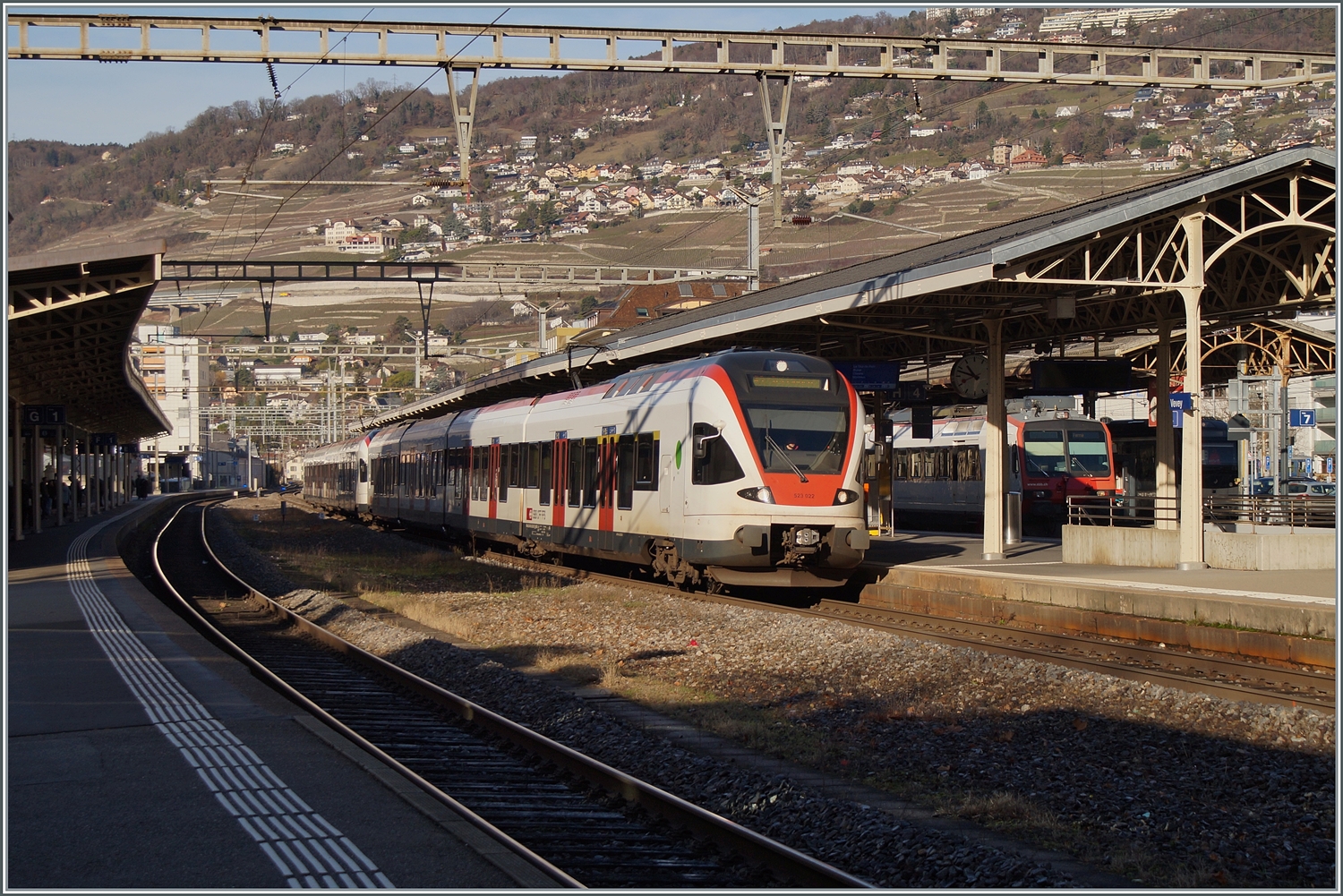 Bei einem tiefen Wintersonnenstand halten zwei SBB RABe 523 Flirt Triebzüge auf dem Weg nach St-Maurice im Bahnhof von Vevey.  

27. Dez. 2023