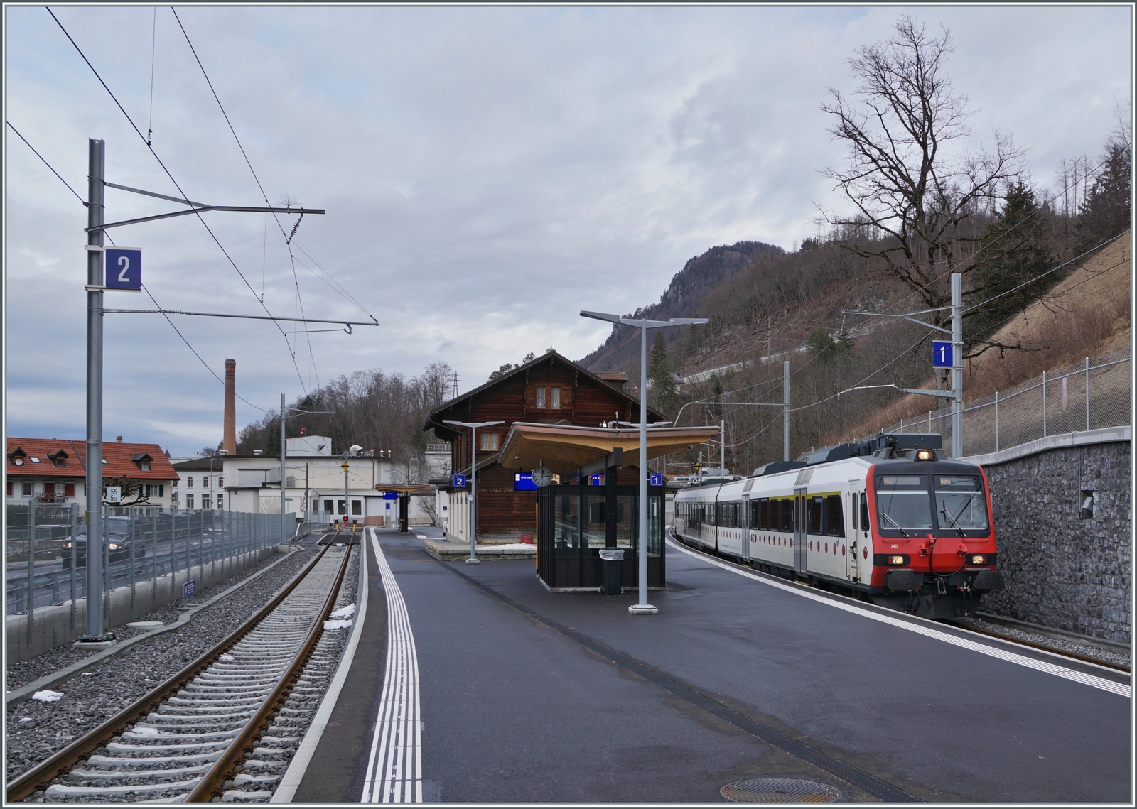 Blick auf den Bahnhof Broc Chocolaterie mit dem TPF RBDe 560 240 (mit dem Steuerwagen ABt 39-43 863-2 an der Spitze), der als RE 3819 auf die baldige Abfahrt nach Bern wartet. 

24. Januar 2024