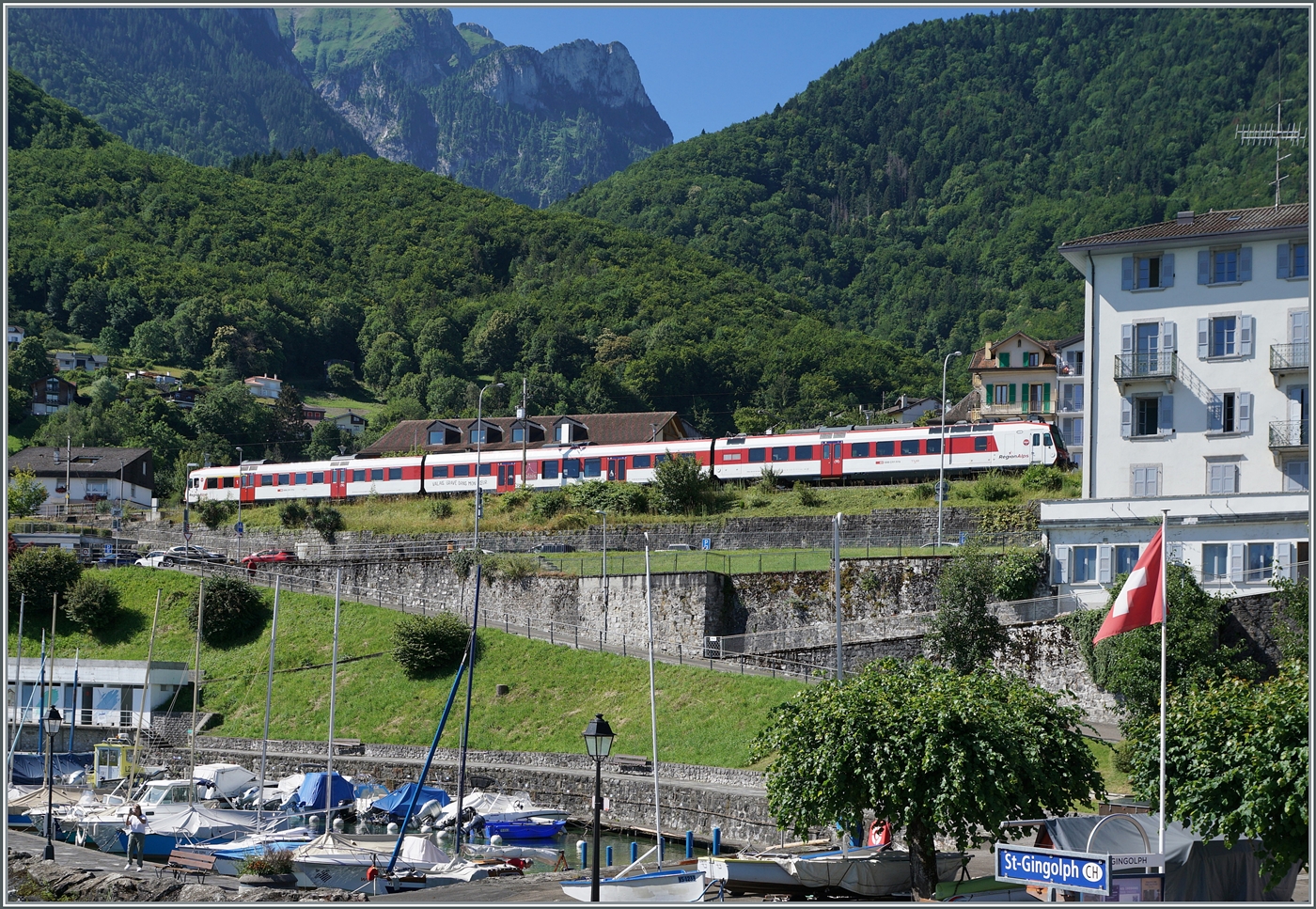 Blick vom Schiff auf  Hafen  und Bahnhof in St-Gingolph; im Bahnhof wendet gerade ein RegionAlps RBDe 560 Domino, wobei da Wenden hier reicht üppig ausgelegt ist: Ankunft xx:06  und Abfahrt XX:51, also gute dreiviertel Stunde.

5. Juli 2024