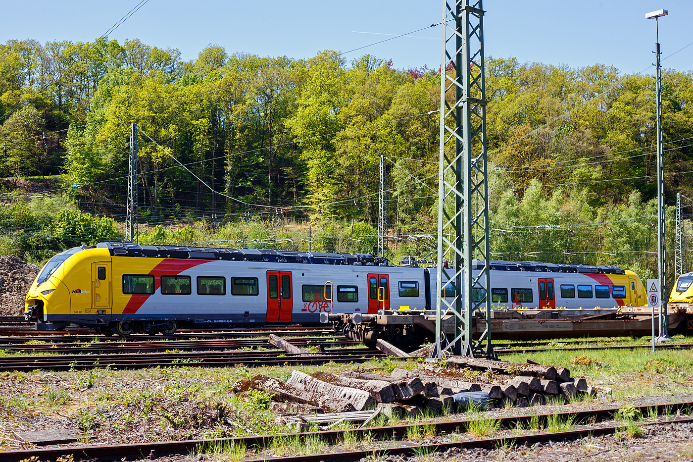 Das ist der neue Klimaschutz am Westerwald....
Zwei der drei neuen zweiteiligen Hybridtriebzge (E/Akku) der BR 563 vom Typ SIEMENS Mireo Plus B der HLB (Hessische Landesbahn GmbH) sind am 30 April 2025 in Betzdorf/Sieg abgestellt. Links der 563 801/563 901 (94 80 0563 801-0 D-HEB / 94 80 0563 901-8 D-HEB) und rechts daneben der 563 803/563 903 (94 80 0563 803-6 D-HEB / 94 80 0563 903-4 D-HEB)

Die beiden zweiteiligen SIEMENS Mireo Plus B wurden 2024 von SIEMENS in Krefeld gebaut. 

Auszug aus der Pressemitteilung der HLB:
Alternative Antriebe im Norden von Rheinland-Pfalz: Durchbruch beim Pilotprojekt mit Batteriezgen im Westerwald / Zuschlag an Siemens Mobility fr Mireo Plus B Fahrzeuge

Als Aufgabentrger fr den Nahverkehr auf der Schiene im Norden von Rheinland-Pfalz setzt sich der SPNV-Nord gemeinsam mit seinen Projektpartnern von Bund, Land und Eisenbahnverkehrsunternehmen (EVU) fr den Einsatz von alternativen Antrieben als Abkehr vom Dieselbetrieb ein.

Dabei konnte bereits im letzten Jahr fr die Beschaffung der Fahrzeuge eine Untersttzung aus dem Frderprogramm des Bundesministeriums fr Digitales und Verkehr (BMDV) fr alternative Antriebe gewonnen werden.

Als Besonderheit sollen im SPNV-Nord erstmalig die beiden Antriebstechnologien fr die Dekarbonisierung des Schienenverkehrs, Wasserstoff und Batterieelektrik, nebeneinander im mehrjhrigen Fahrgastbetrieb zum Einsatz kommen mit einer vollstndigen Rckfallebene mit Dieselfahrzeugen.

Das betrifft auch den Pilotbetrieb mit drei batterie-elektrischen Fahrzeugen im Westerwald, der zum Fahrplanwechsel im Dezember 2025 geplant ist. Dieser sieht einen Fahrzeugeinsatz auf der RB 90 Limburg – Au – Siegen (Oberwesterwaldbahn und Siegstrecke) und auf der RB 29 Limburg – Siershahn (Unterwesterwaldbahn) durch die Hessische Landesbahn (HLB) vor. Bei diesem Pilotprojekt wurde jngst ein wichtiger Durchbruch erzielt:

Als Ergebnis der von der HLB dafr durchgefhrten Fahrzeugausschreibung hat Siemens Mobility jetzt den Zuschlag fr drei zweiteilige Mireo Plus B Batteriezge erhalten. Das Fahrzeug mit seiner hohen Antriebsleistung ist fr den anspruchsvollen Einsatz im Westerwald bestens geeignet. Der geplante Einsatz der drei Batteriezge auf den Linien RB 90 und RB 29 umfasst eine Jahresfahrleistung von fast 400.000 Zug-km und ersetzt drei Dieselfahrzeuge. Da die HLB emissionsfreien Bahnstrom bezieht, werden jhrlich fast 1.150 Tonnen CO2 eingespart. Der Betrieb der Batteriefahrzeuge erfordert keine neue Infrastruktur, denn die Wendezeiten in Limburg von ber 20 Minuten auf der RB 29 werden fr die Aufladung der Fahrzeuge ausreichend sein. Bei den auf der RB 90 verkehrenden Batteriefahrzeugen erfolgt dies im elektrifizierten Abschnitt zwischen Au und Siegen. Die Oberwesterwaldbahn (Limburg – Au) ist mit der Lnge von rund 75 km und der zu berwindende Hhe von ca. 350 m derzeit in Deutschland die anspruchsvollste Strecke fr den vorgesehenen Einsatz von Batteriezgen.

Die Ausschreibung der Batteriefahrzeuge war so ausgestaltet, dass die Hersteller die Mglichkeit hatten, die Fahrzeuge in laufende Bestellungen zu integrieren, so dass eine schnelle Lieferzeit in Aussicht gestellt wurde.

Siemens Mobility baut fr den Einsatz im Westerwald drei zweiteilige Mireo Plus B Batteriezge, die durch jeweils drei Tren pro Seite einen schnellen Ein- und Ausstieg ermglichen. Die Zge verfgen fr den Betrieb unter Oberleitung und zum Aufladen der Batterien ber einen Stromabnehmer und verkehren auf den nicht-elektrifizierten Strecken im Batteriebetrieb. Die gerumigen Fahrzeuge bieten den Fahrgsten 126 Sitzpltze und 156 Stehpltze und sind mit einer speziellen Einstiegshilfe ausgestattet, die mobilittseingeschrnkten Menschen das Bahnfahren erleichtert.

Die neuen Batteriezge werden auf der Oberwesterwaldbahn Limburg – Altenkirchen - Au - Siegen, und auf der Unterwesterwaldbahn zwischen Limburg – Montabaur – Siershahn unterwegs sein. Die Strecke der OWB betrgt ca. 115 km, davon sind ca. 75 km ohne Fahrdraht. Es ist vorgesehen die Zge in Limburg und auf dem Teilabschnitt Au – Siegen nachzuladen. Auf der UWB betrgt die nicht elektrifizierte Strecke ca. 35 km. Damit ist ein Zugbetrieb hin und zurck ohne Nachladen mglich. Insgesamt werden die Zge ber 50 Bahnhfe anfahren.

TECHNISCHE DATEN:
Spurweite: 1.435 mm
Achsfolge: Bo’-2’-Bo’
Fahrzeuglnge ber Kupplung: 46.560 mm
Drehzapfenanstand: 2 x 17.930 mm
Anzahl der Tren je Seite: 3
Installierte Leistung: 1.700 kW
Leistungsbertragung: elektrisch
Motoren: 2 Drehstrom-Asynchronmotoren
Hchstgeschwindigkeit: 140 km/h 
Kupplung: Mittelpufferkupplung Schaku Typ 10
kleinster befahrbarer Gleisbogen: R 150 m (Normal) / R 100 m (Werkstatt)

Ein kleiner Nachteil gegenber den LINT-Dieseltriebzgen ist mir aufgefallen, die Gesamt-Fensterflche ist geringer. Ich bin aber sehr gespannt auf den Betriebseinsatz und wie es luft.
