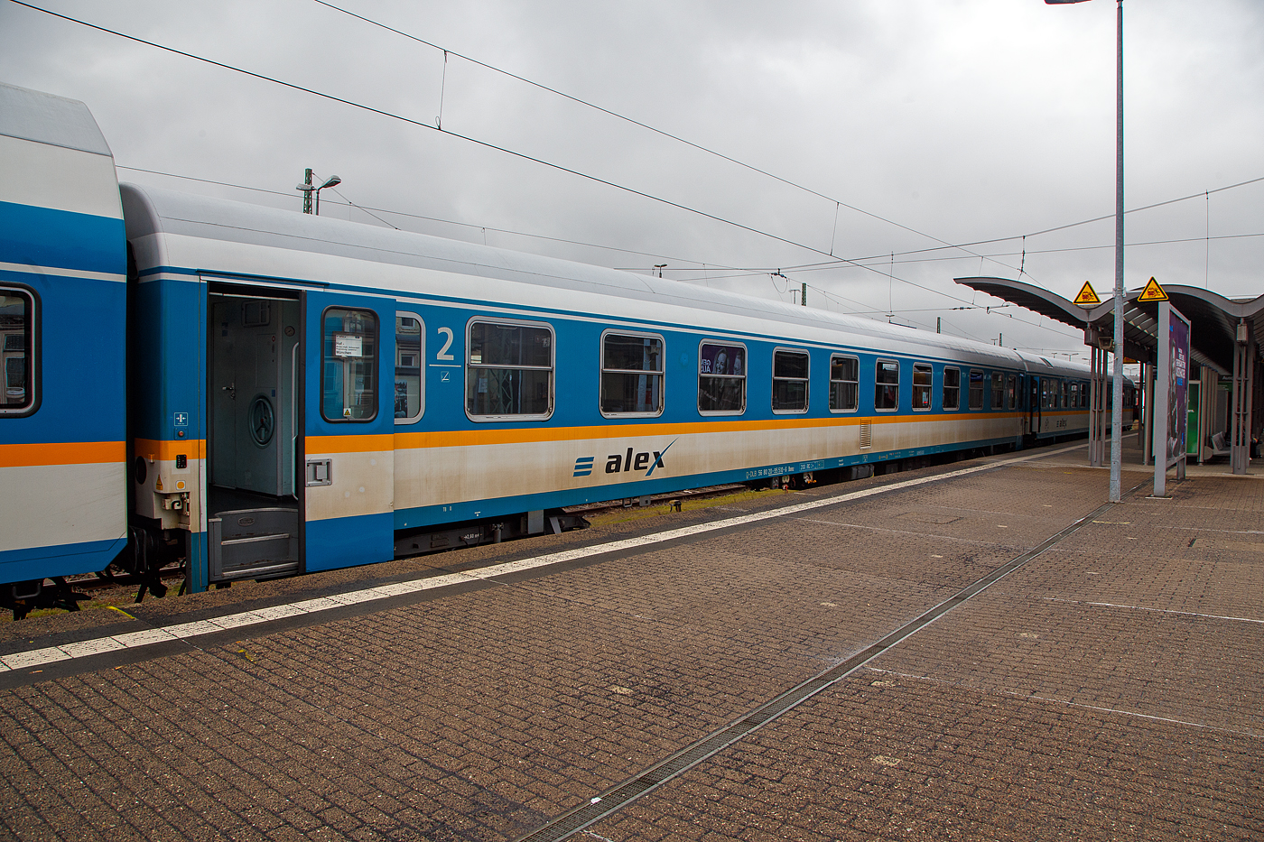 Der „alex“ zweite Klasse Reisezugwagen D-DBL 56 80 20-95 510-6 der Gattung Bomz (ex DB 51 80 10-94 009-7 Amz 210.0), der DBL - Die Länderbahn GmbH, eingereiht in einen RE nach München Hbf, am 17 April 2023 im Hbf Hof.

Die Wagen der ehemaligen Gattung Amz 210 und Amz 210.1 sind die jüngsten Fahrzeuge im Bestand des ALEX. Die Wagenserie entstand 1991 beim Waggonbau Bautzen (ehemals LOWA, später Deutsche Waggonbau AG (DWA), jetzt Bombardier) noch im Auftrag der Deutschen Reichsbahn. Sie entstanden nach dem Vorbild der Ame-Wagen des RAW Halberstadt (spätere Am 201) und den UIC-Z-Normen. Es wurden insgesamt 40 Wagen gebaut, die ab Werk im blauen Interregio-Farbschema lackiert waren, innen jedoch noch klassische Schnellzugwagen waren. Eingesetzt wurden sie bis 2002 im Interregioverkehr. Zum Schluss liefen sie teilweise noch in Regionalexpresszügen, im Jahr 2003 wurde diese Wagenserie (gerade einmal 12 Jahre alt!) komplett ausgemustert. 22 Wagen dieses Typs konnte die Regentalbahn von der DB kaufen, 2 Wagen wurden als Ersatzteilspender verwendet, so dass sich aktuell 20 Wagen im Bestand des ALEX befinden.

Drei der ehemaligen Amz 210 wurden nicht in ABvmz umgebaut, sondern als unklimatisierte Abteilwagen 2. Klasse hergerichtet, indem lediglich die alte Einrichtung im Design des neuen alex aufgearbeitet wurde. 

Zur Einsetzbarkeit: 
Die Wagen mit den Ziffern 90 an der 7. und 8. Stelle der Wagennummer sind mehrspannungsfähig, die Wagen mit den Ziffern 95 (wie dieser hier) an dieser Stelle sind nur einspannungsfähig - die Versorgung der Zugsammelschiene ist nur mit der in Deutschland üblichen Spannung von 1000V und 16 2/3 Hz möglich.

TECHNISCHE DATEN:
Hersteller: WB Waggonbau Bautzen 
Baujahr: 1991
Spurweite: 1.435 mm
Länge über Puffer: 26.400 mm
Wagenkastenlänge: 26.100 mm
Drehzapfenabstand: 19.000 mm
Achsstand im Drehgestell: 2.600 mm
Drehgestellbauart: GP 200-S-Mg
Leergewicht: 40 t
Höchstgeschwindigkeit: 200 km/h
Zulassungen: D (1000V 16 2/3 Hz)
Sitzplätze: 60 in der 2. Klasse in 10 Abteilen
Toiletten: 2
Bremsbauart: KE-GPR-Mg (D)