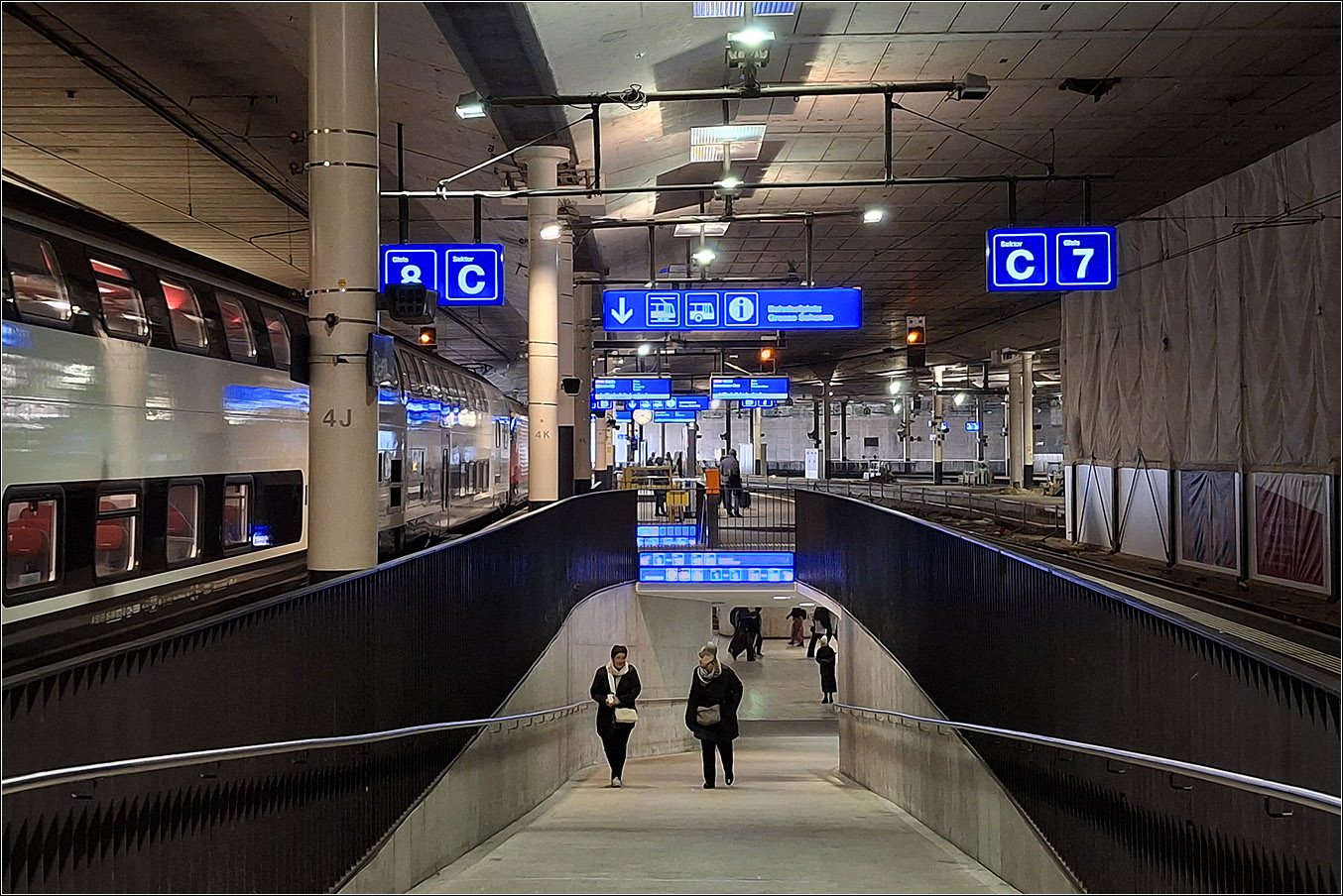 Der Bahnhof Bern - 

Ein Großteil der Bahnsteige sind durch ein Parkdeck überbaut, daher hat der Bahnhof einen weitgehenden unterirdische Charakter. Die Bauzeit des Bahnhofes mit abschnittsweiser Inbetriebnahme dauerte 17 Jahre, damit vielleicht etwas länger als Stuttgart 21.

Rampen und auf der anderen Seite feste Treppen führen von der Bahnsteigunterführung hinauf zu den Bahnsteigen. Ein zweite großzügiger Unterführung entsteht weiter westlich im Zusammenhang mit dem Neubau des großen unterirdischen Bahnhofes für die RBS.

05.03.2025